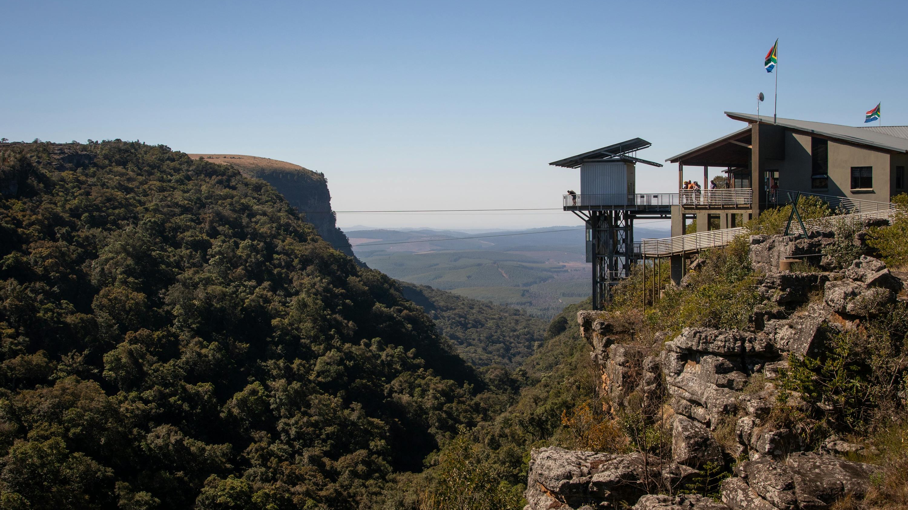 A small viewing building perched on the edge of a gorge covered with lush foliage.