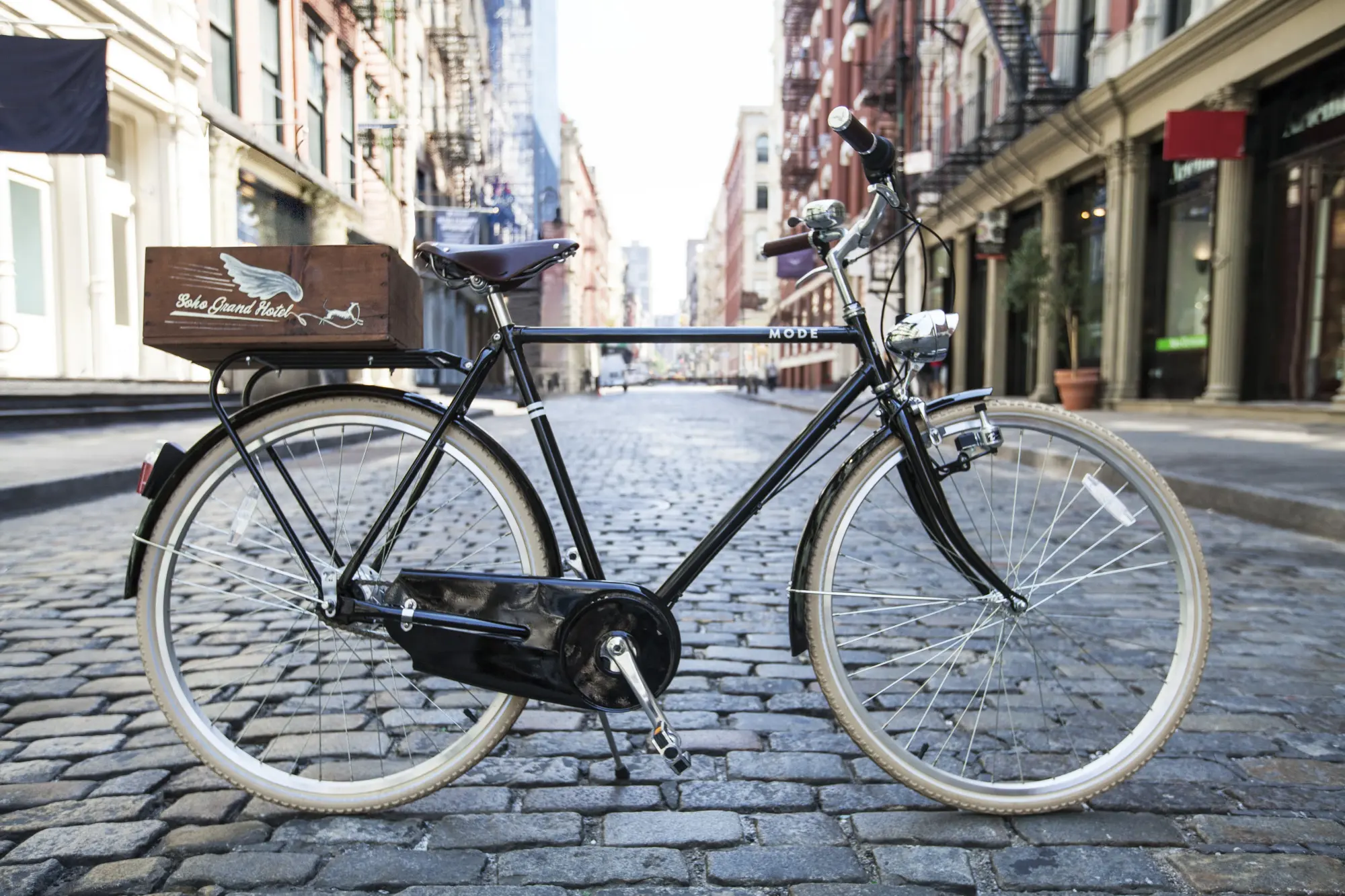 A vintage cruising bike artistically placed in the middle of a cobblestone street with SoHo's classic architecture in the background