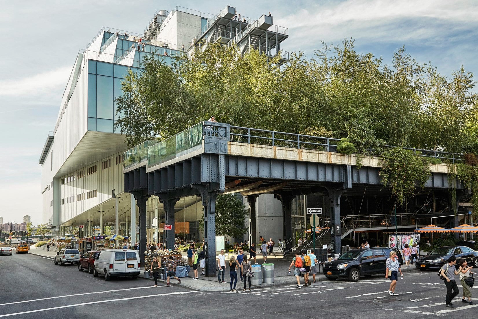 The unique, geometric architecture of the Whitney Museum in New York City, with hanging gardens and a busy intersection in front