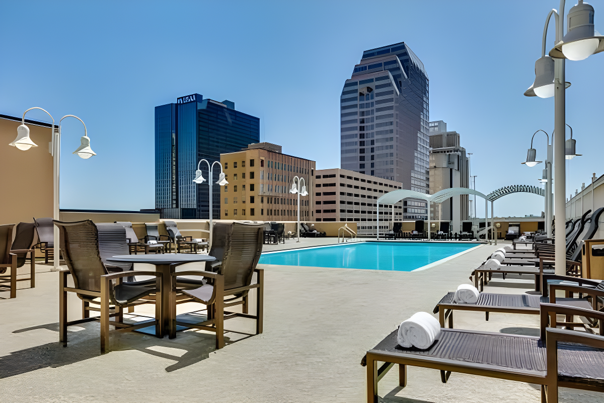 a rooftop urban pool surrounded by lounge chairs