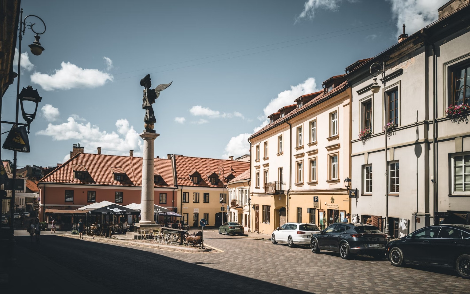 A town street next to white, attached buildings