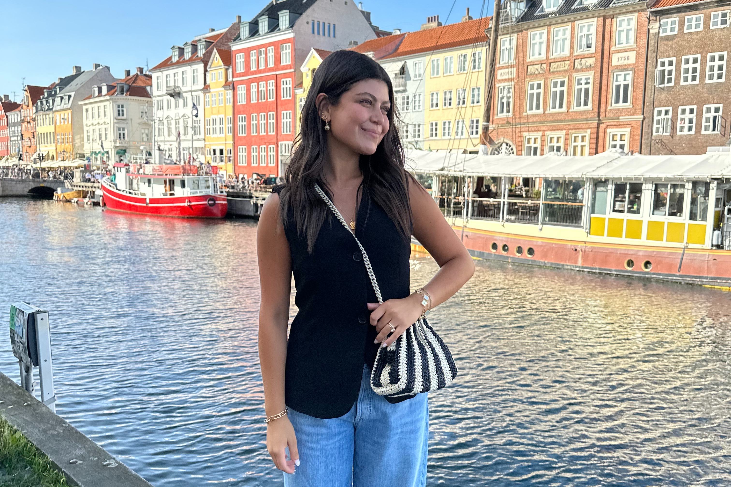 Advisor posing in front of colored houses at Christianshavn, a vibrant, canal-filled district in Copenhagen.