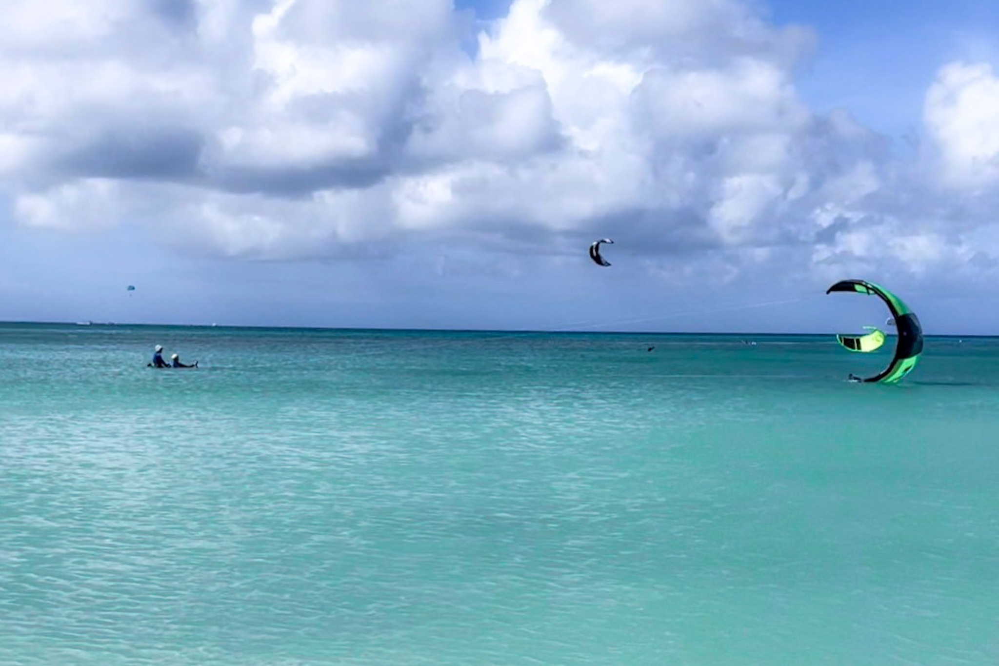 People wind surfing in the ocean during the daytime