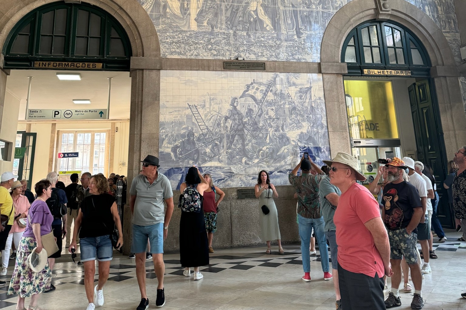 People walking around a room with a large blue and white wall mural