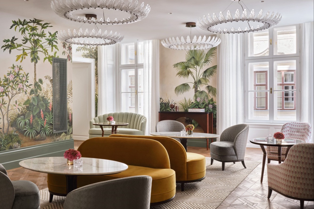room with tables, velvet seating and palm tree murals