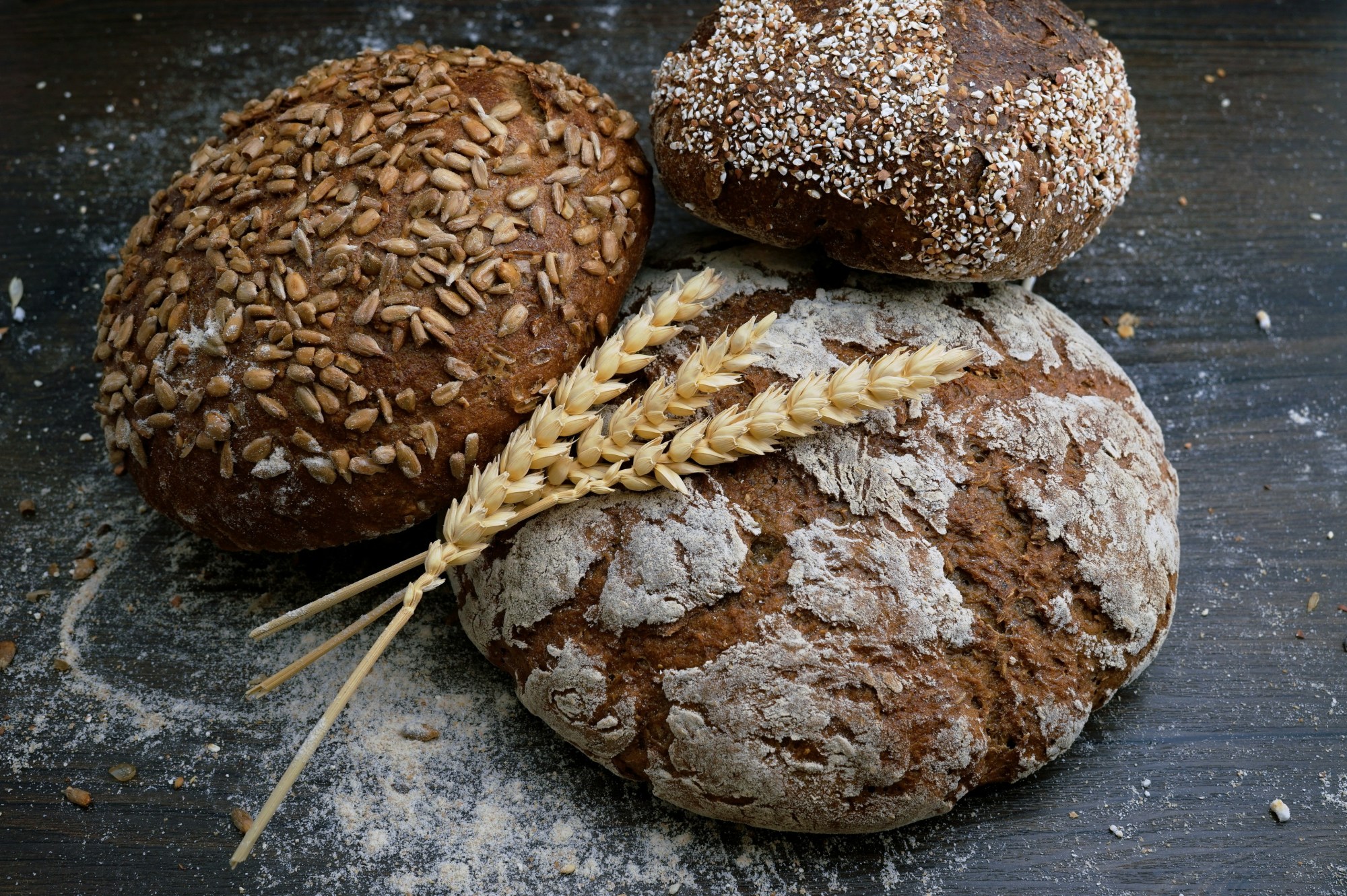 Loaves of bread stacked on a floured surface.
