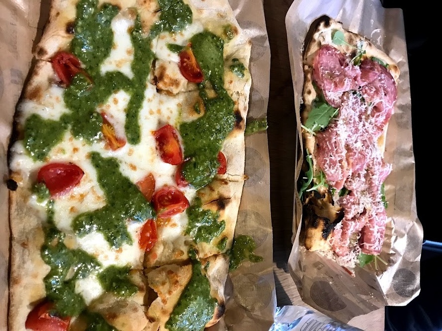 Two steaming Italian pizzas artfully arranged in parchment.
