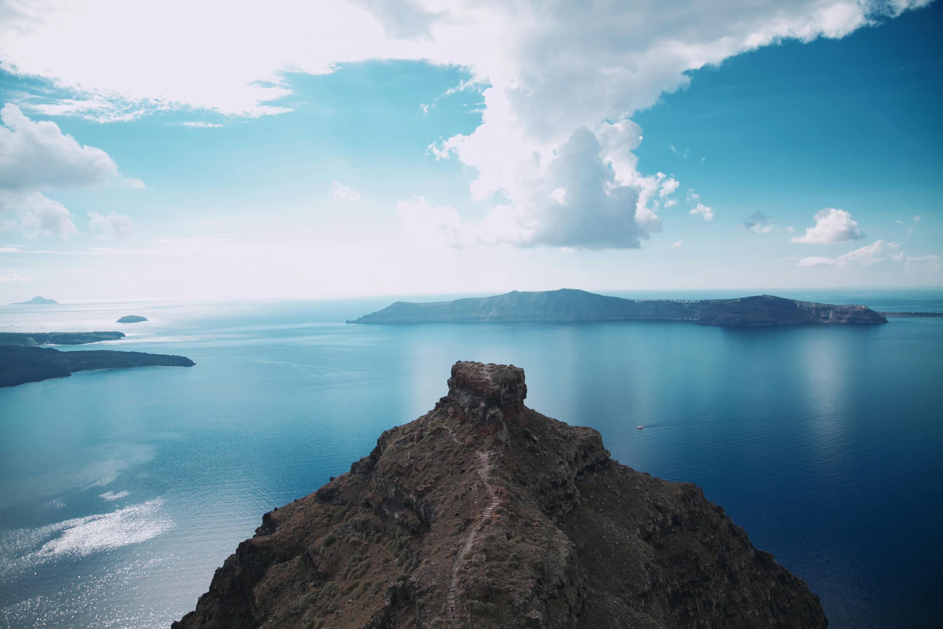 The Caldera, overlooking a body of water in Santorini looks serene under the blue skies.