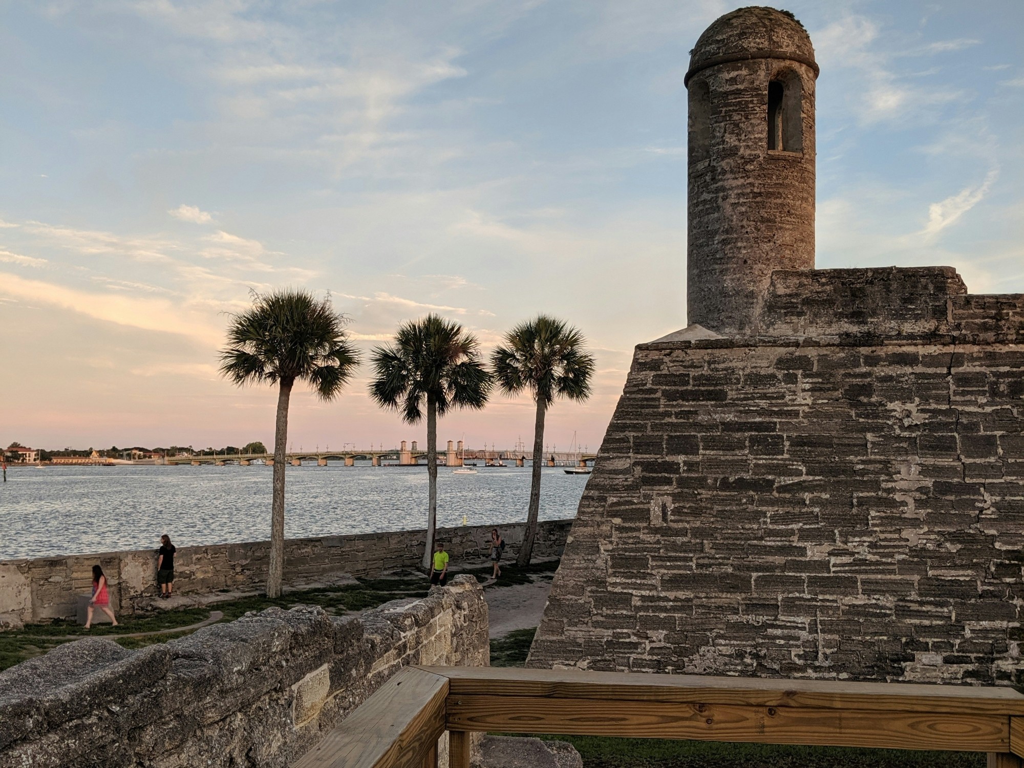 An old fort next to a body of water during the sunset