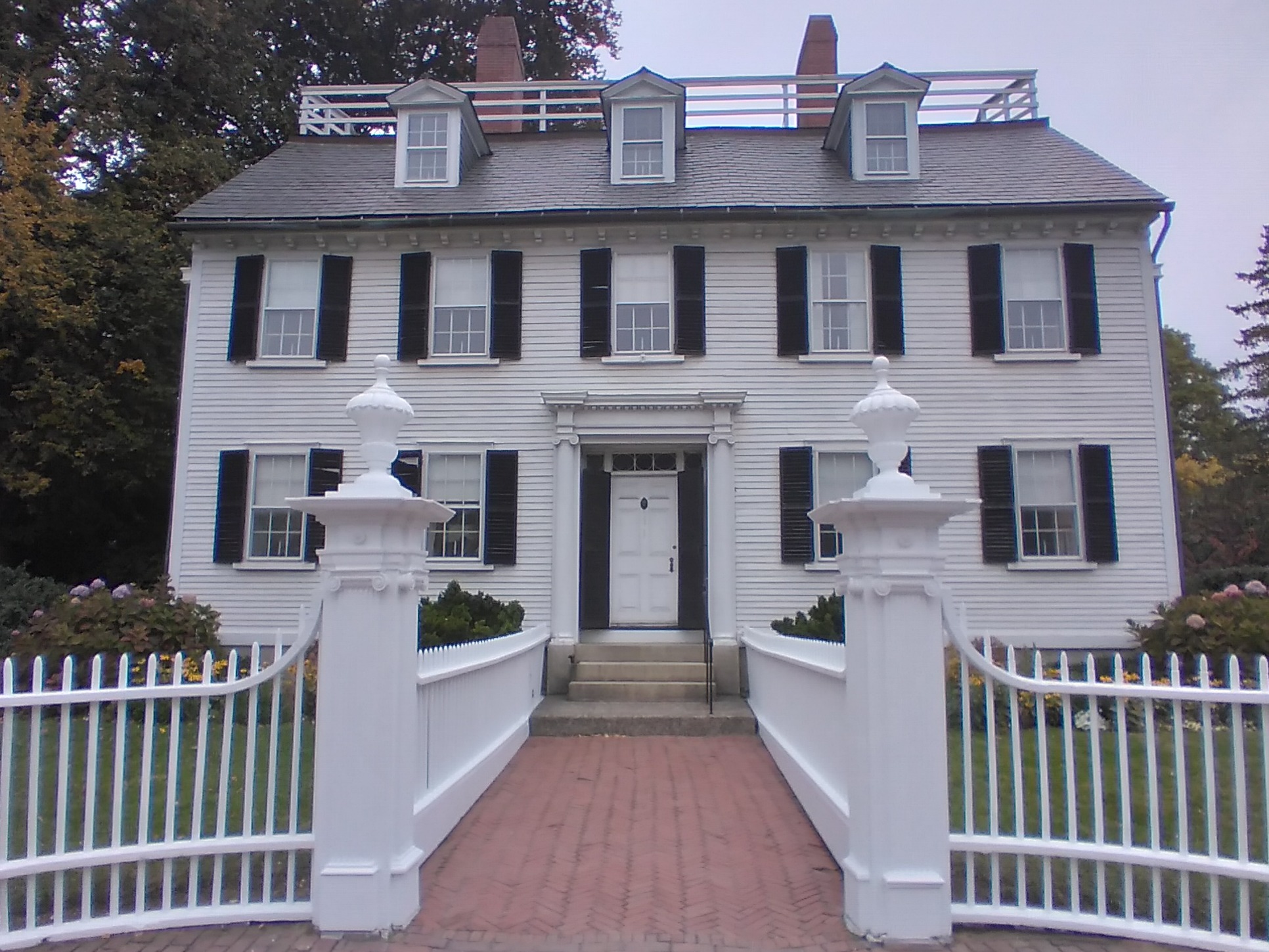Historical, white building with white picket fence.