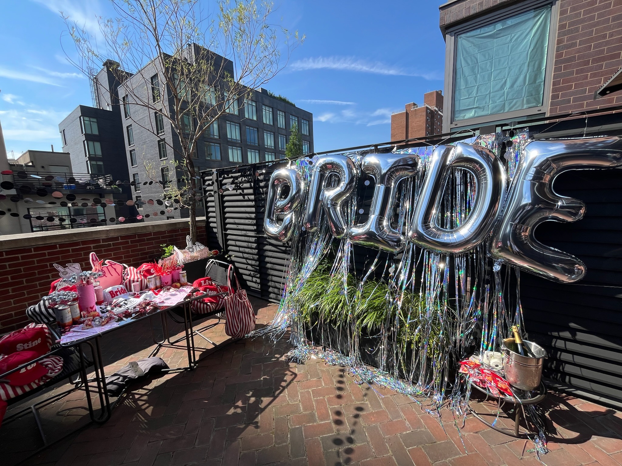 An outdoor celebration area with “BRIDE” balloons and festive decorations.
