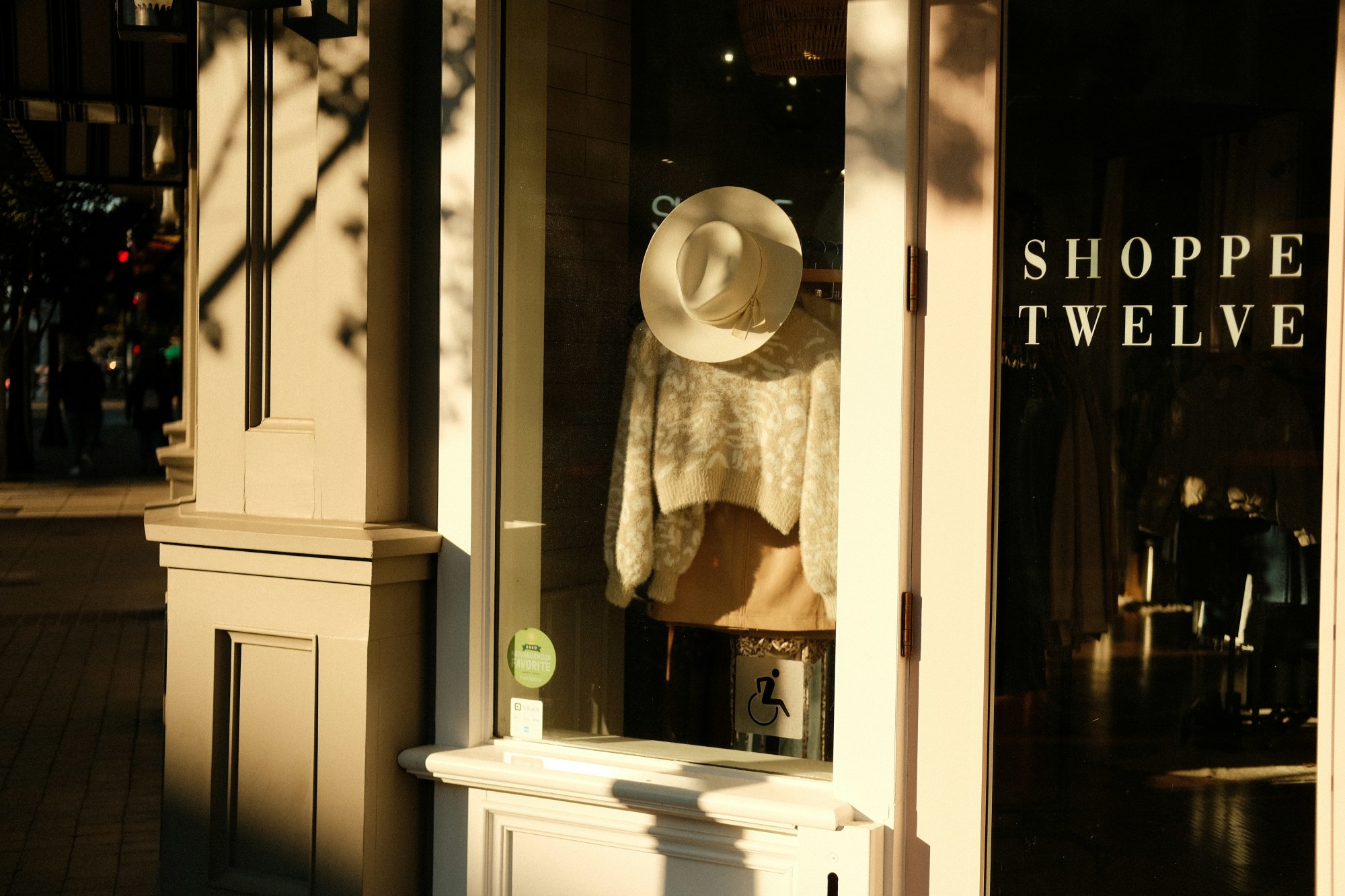A storefront with a hat over sweater on display.
