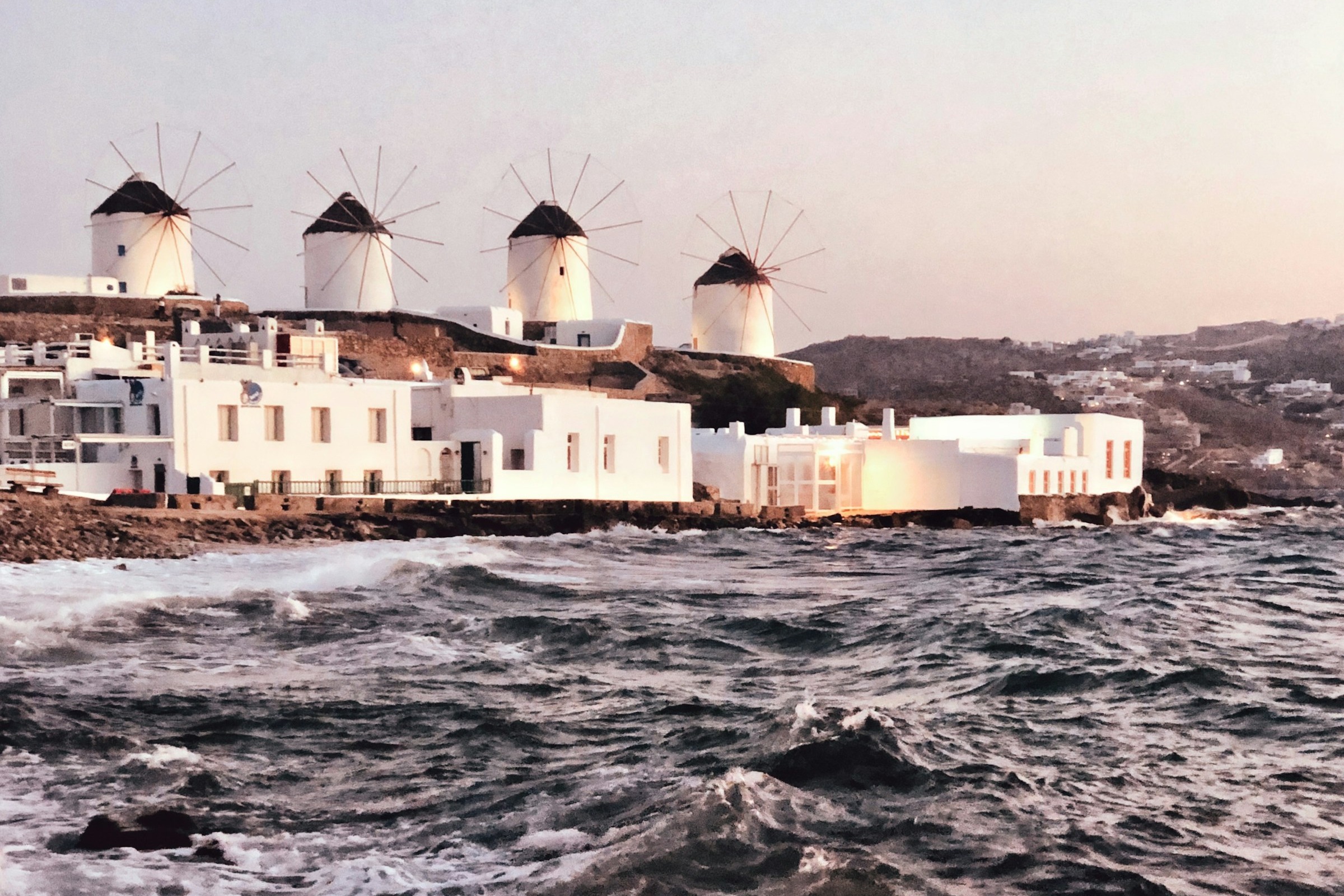 Windmills that stand in a row, overlooking the sea by Little Venice on a sunny day.
