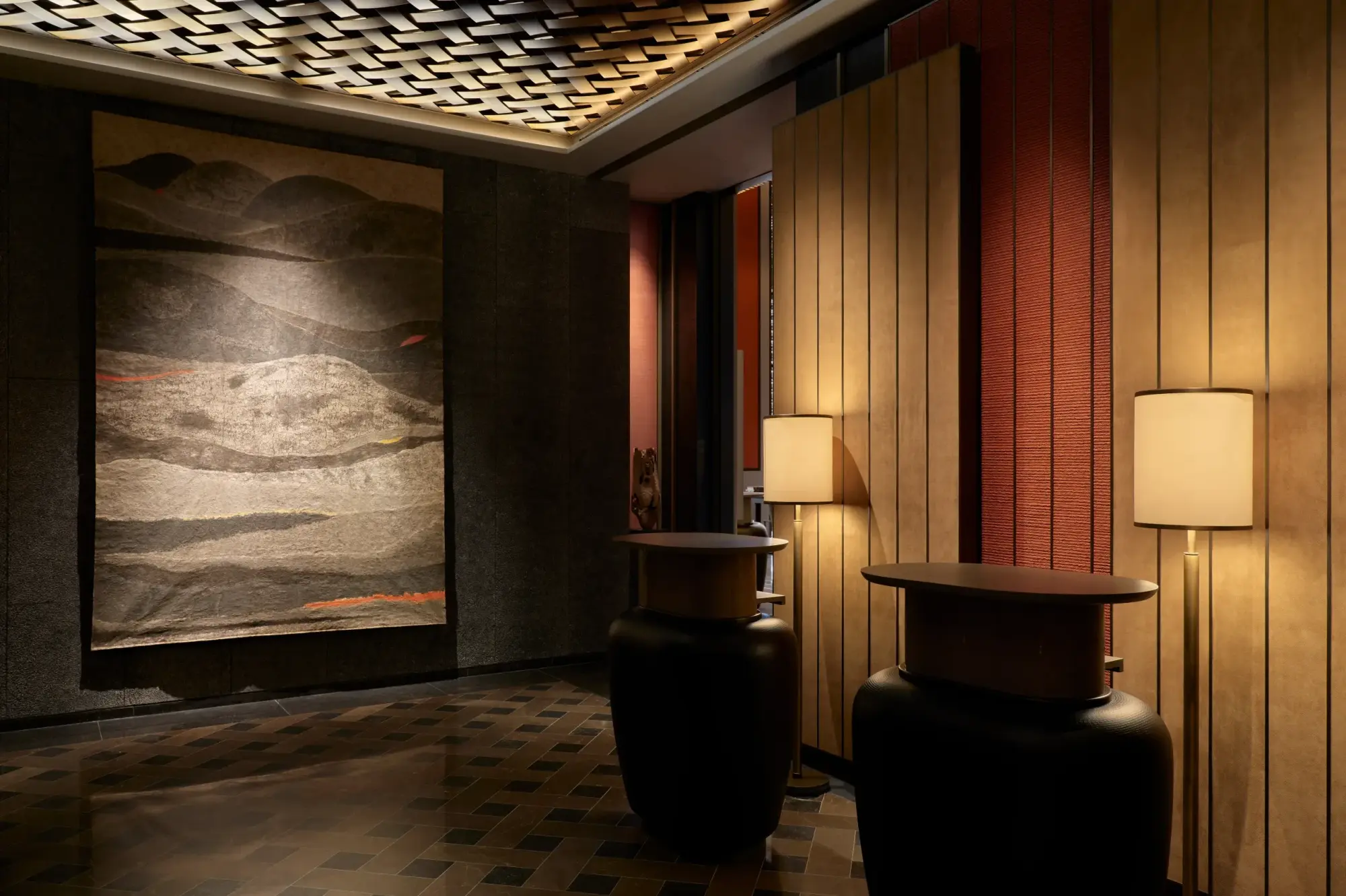 A dim-lit corridor with classy, contemporary art and decor with Japanese influences. The aesthetic is luxurious and design-forward