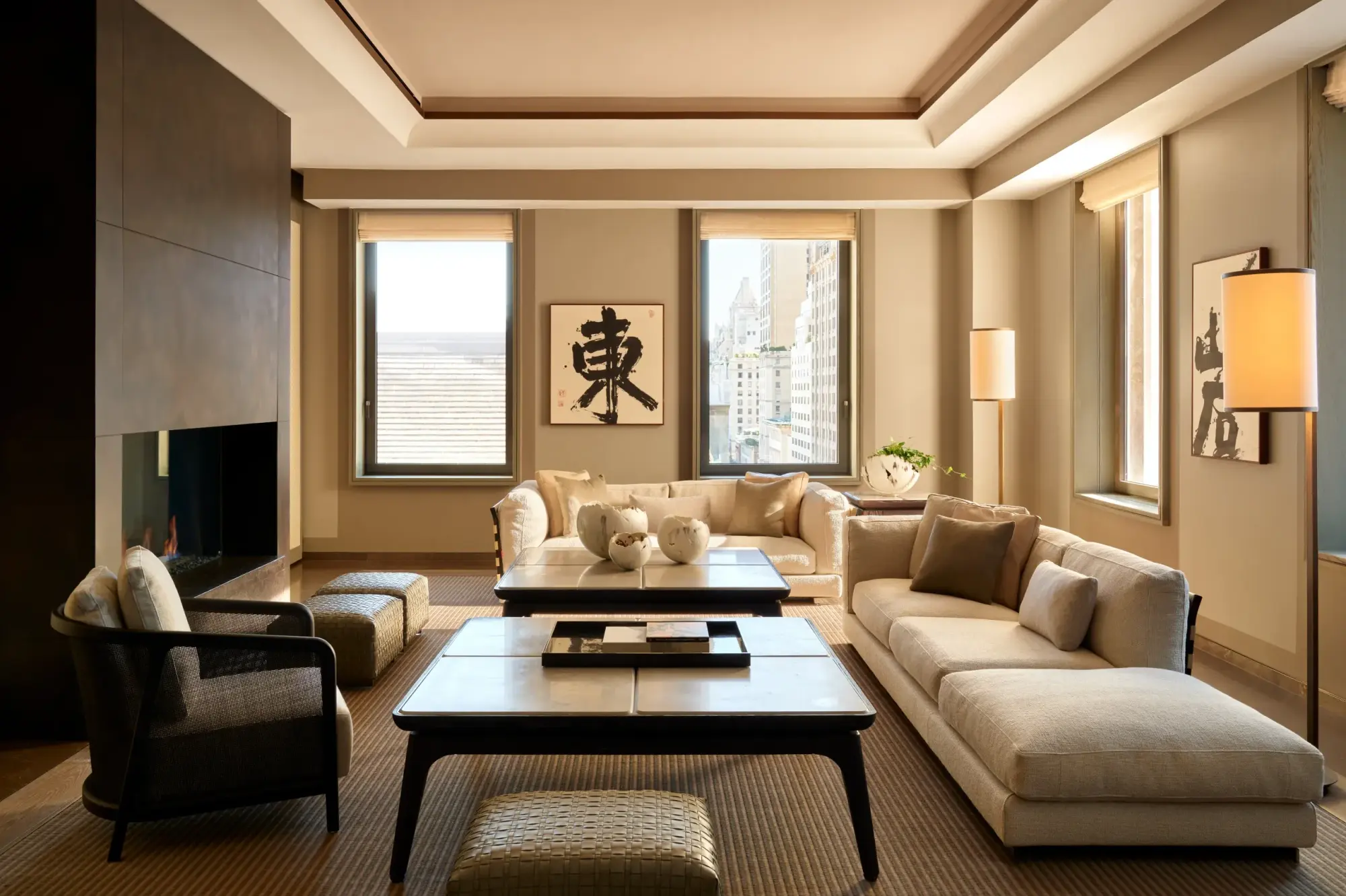 Sleek, minimalist furniture with contemporary and traditional Japanese decor in a spacious living room space. Large windows reveal the New York City skyline