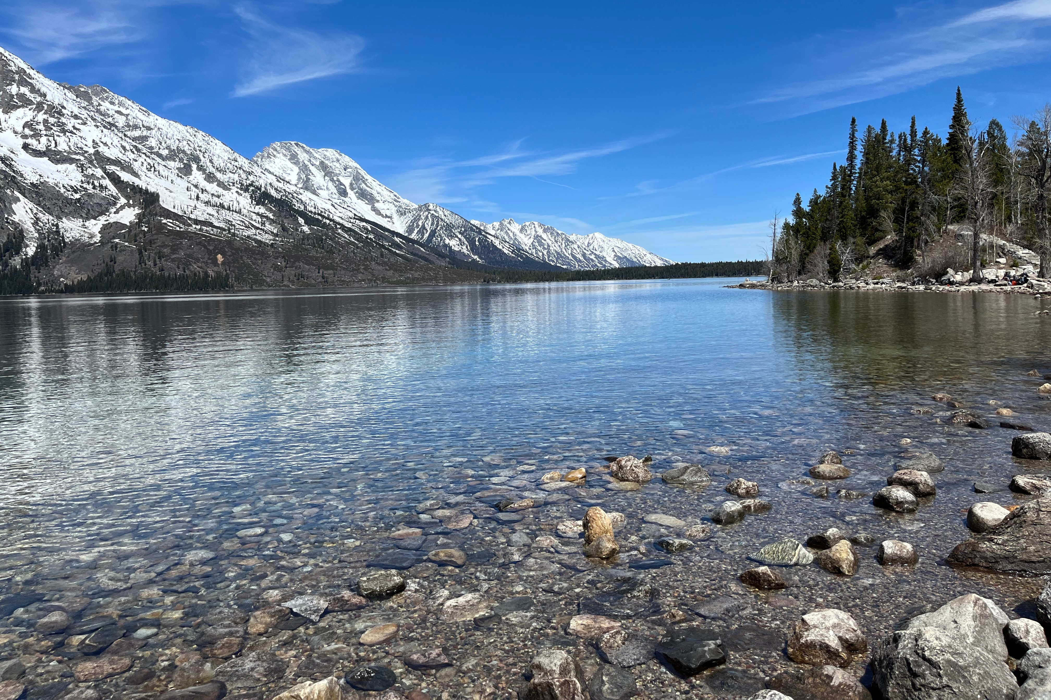 A lake in front of a snow-covered mountain during the daytime