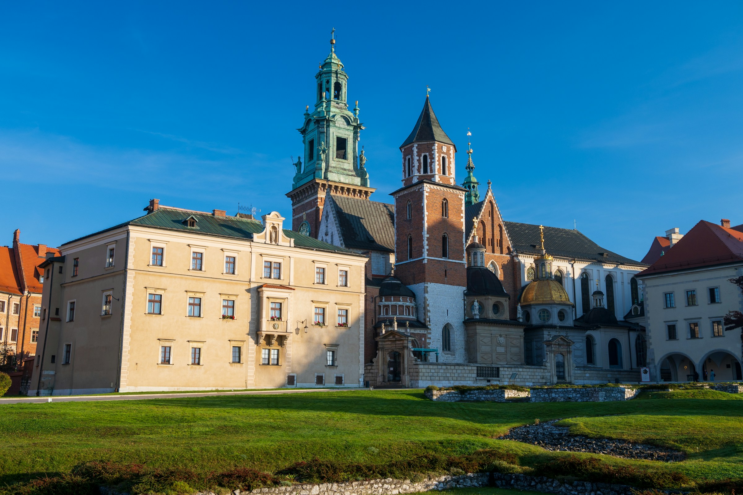Wawel Royal Castle is a historic landmark in Kraków perched atop Wawel Hill on sunny day.