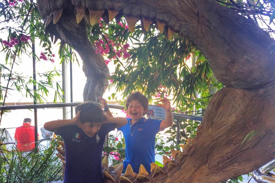 The kids are having fun at a dinosaur mouth in Barcelona Aquarium.