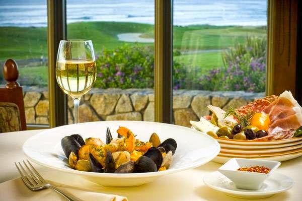 Plates of food on a table, in front of a window with a view of the gold course