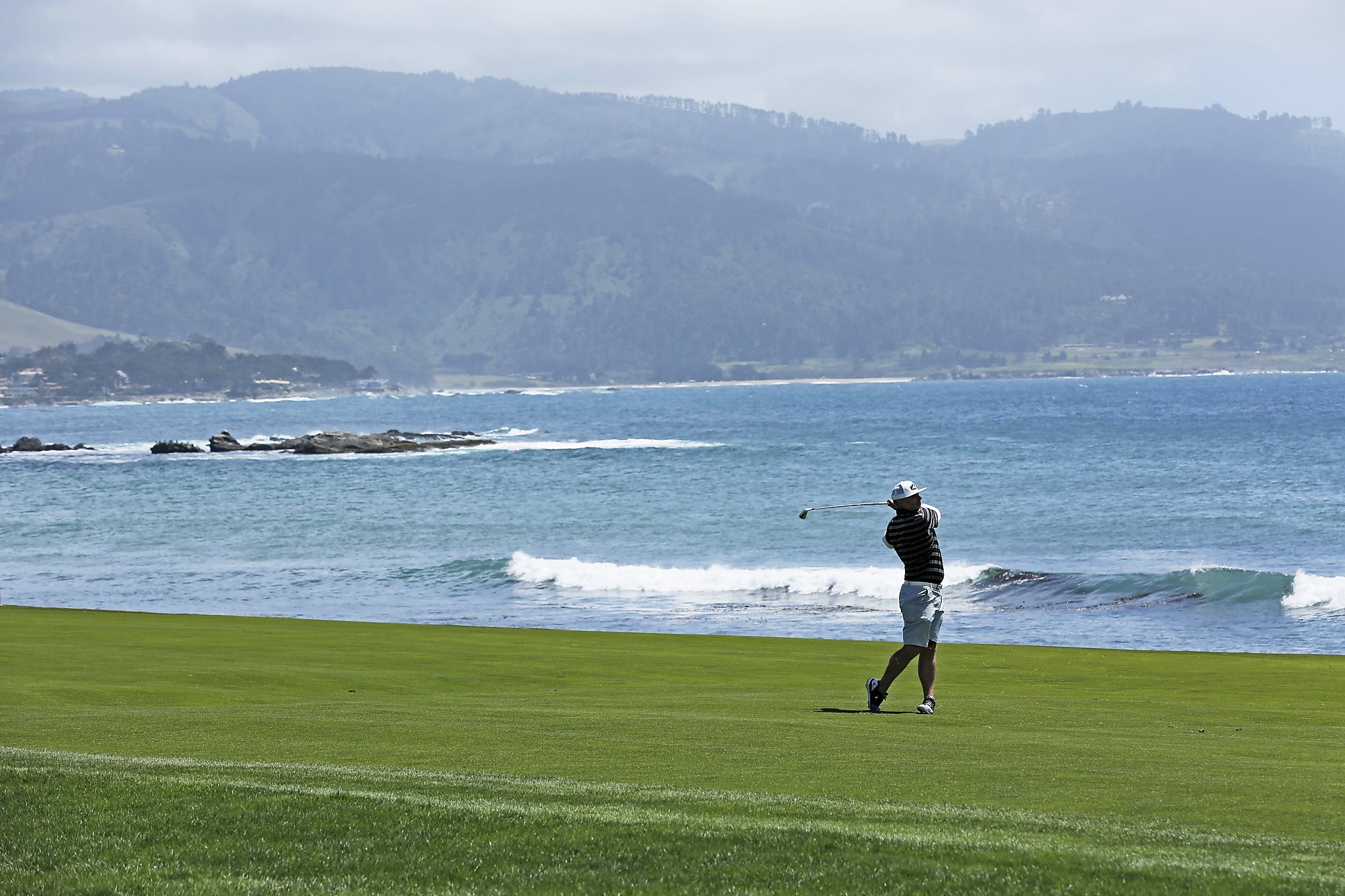 Playing golf with the view of Pebble Beach.