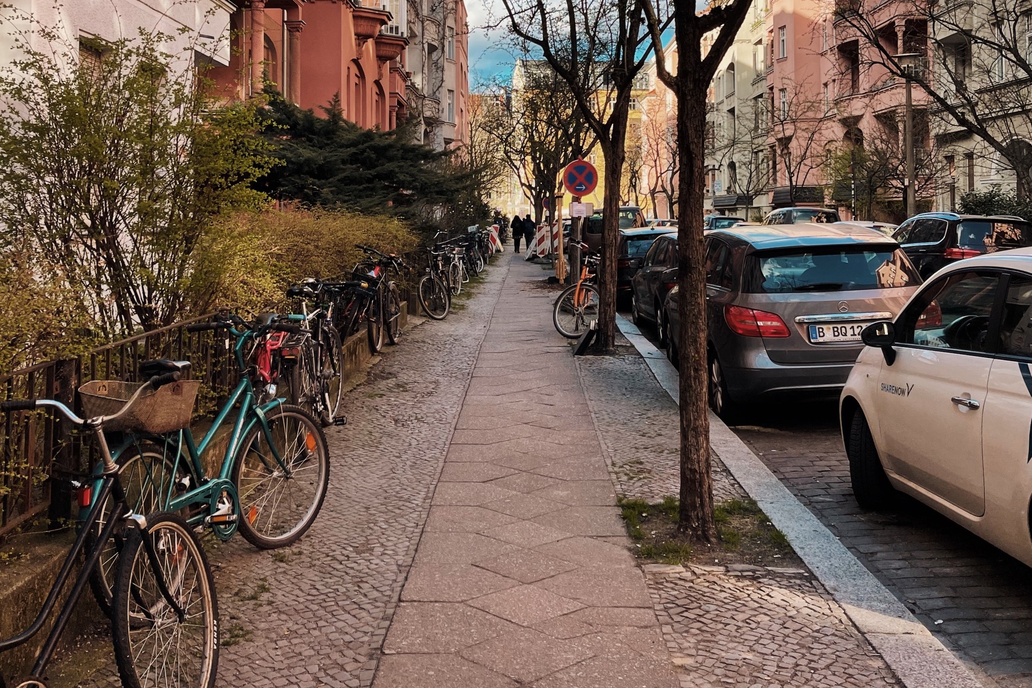 A picture of a street with vehicles parked on the side during daytime.