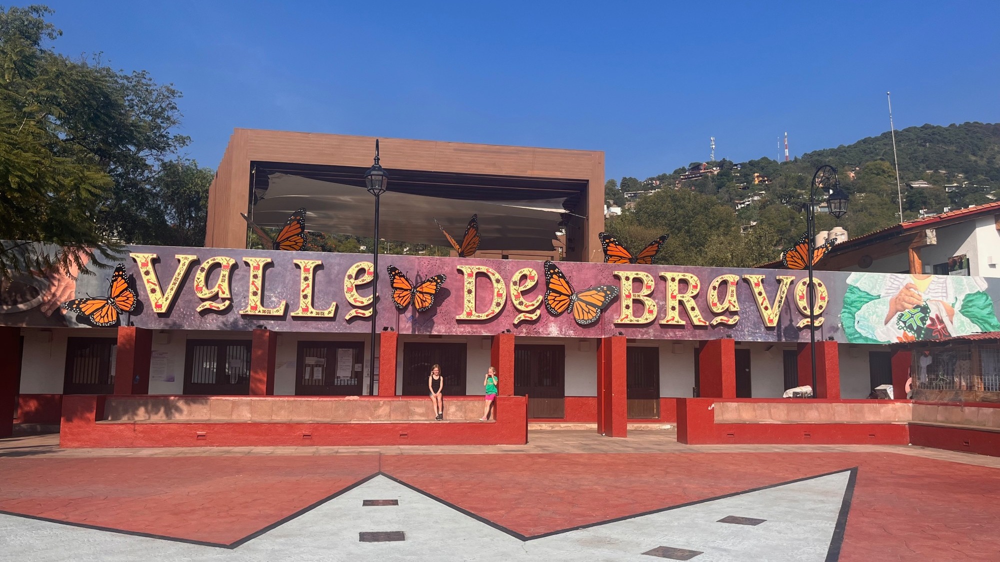 Red building with butterfly sculptures mounted on it.