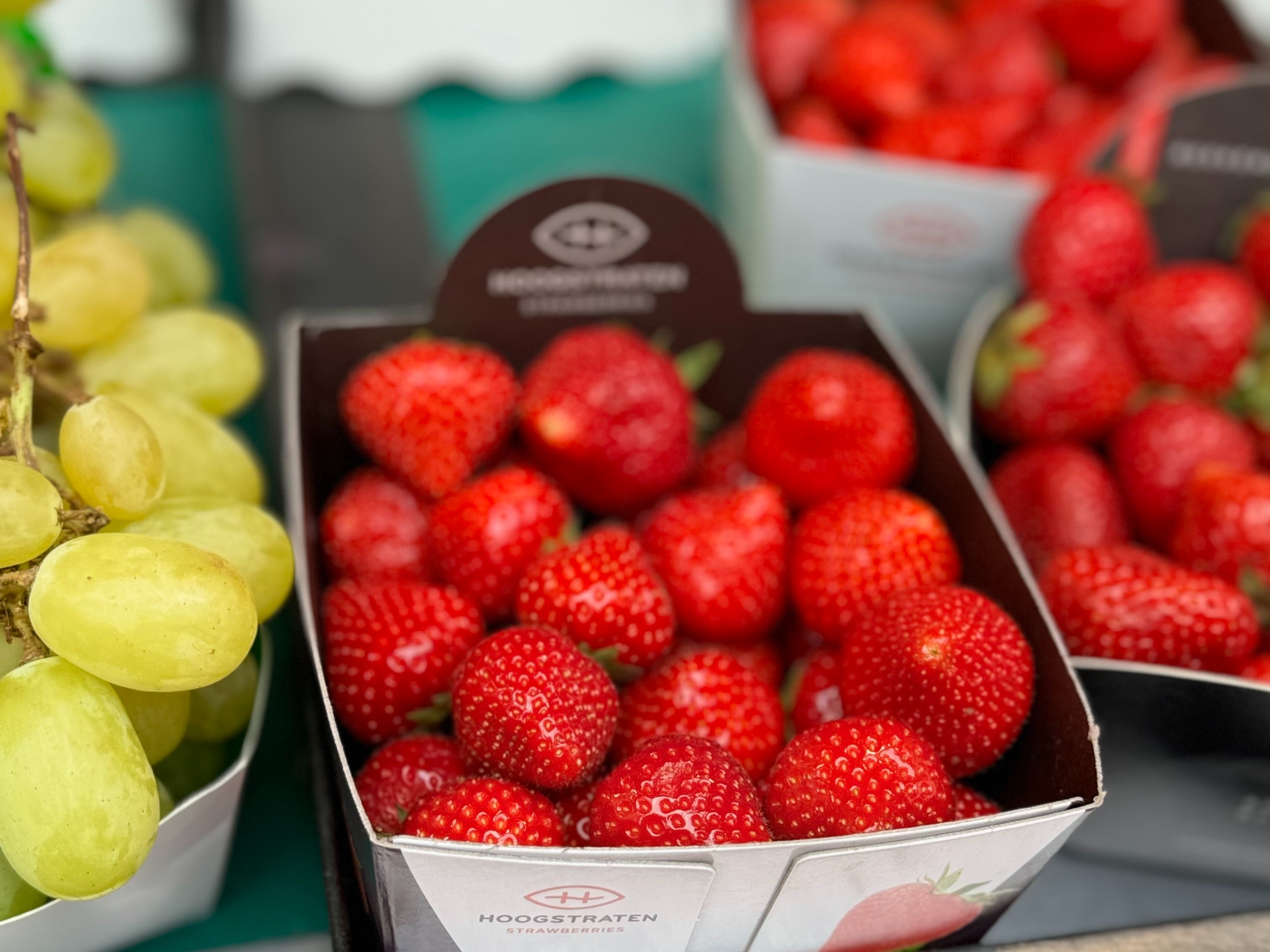 Boxes of strawberries on display at a market.