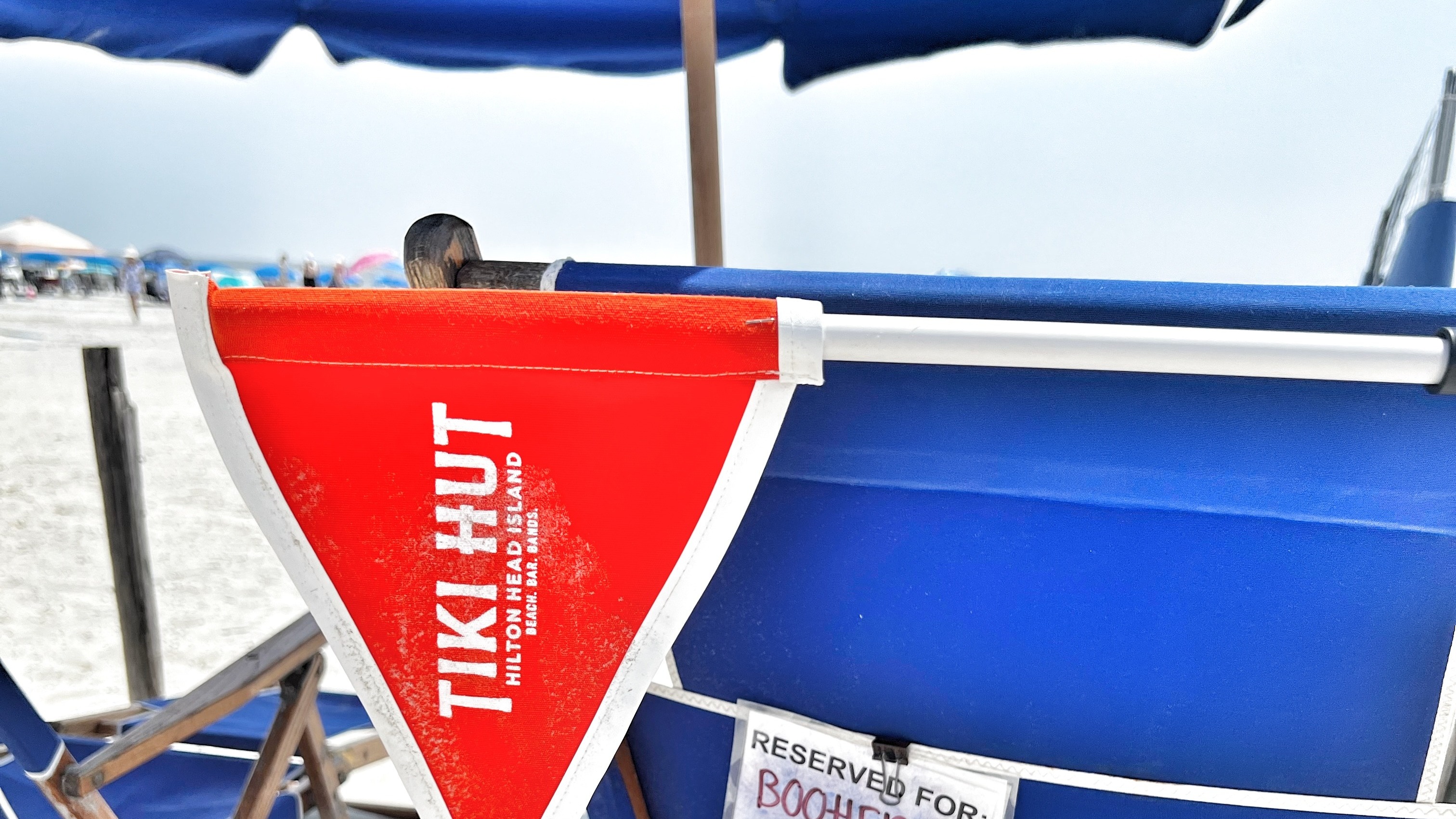A shade umbrella branded with the name "Tiki Hut."