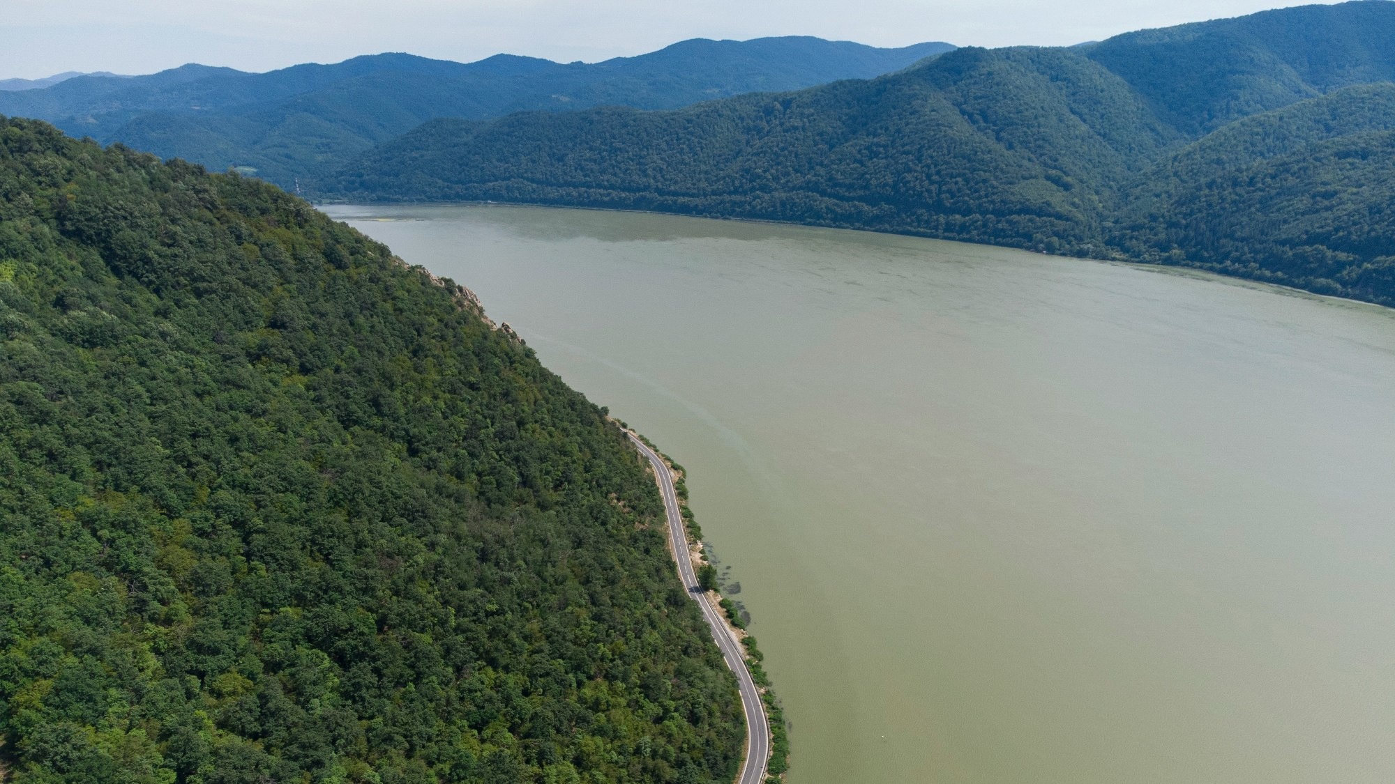 A river flowing between tree-covered mountains.