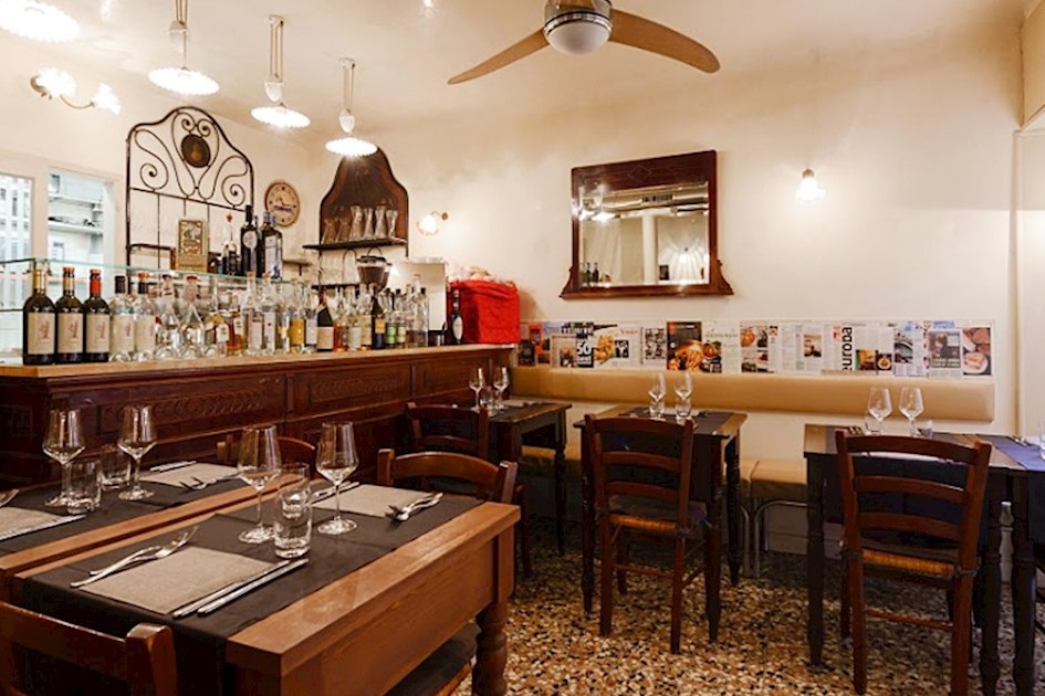 An intimate restaurant with wooden tables and white walls.