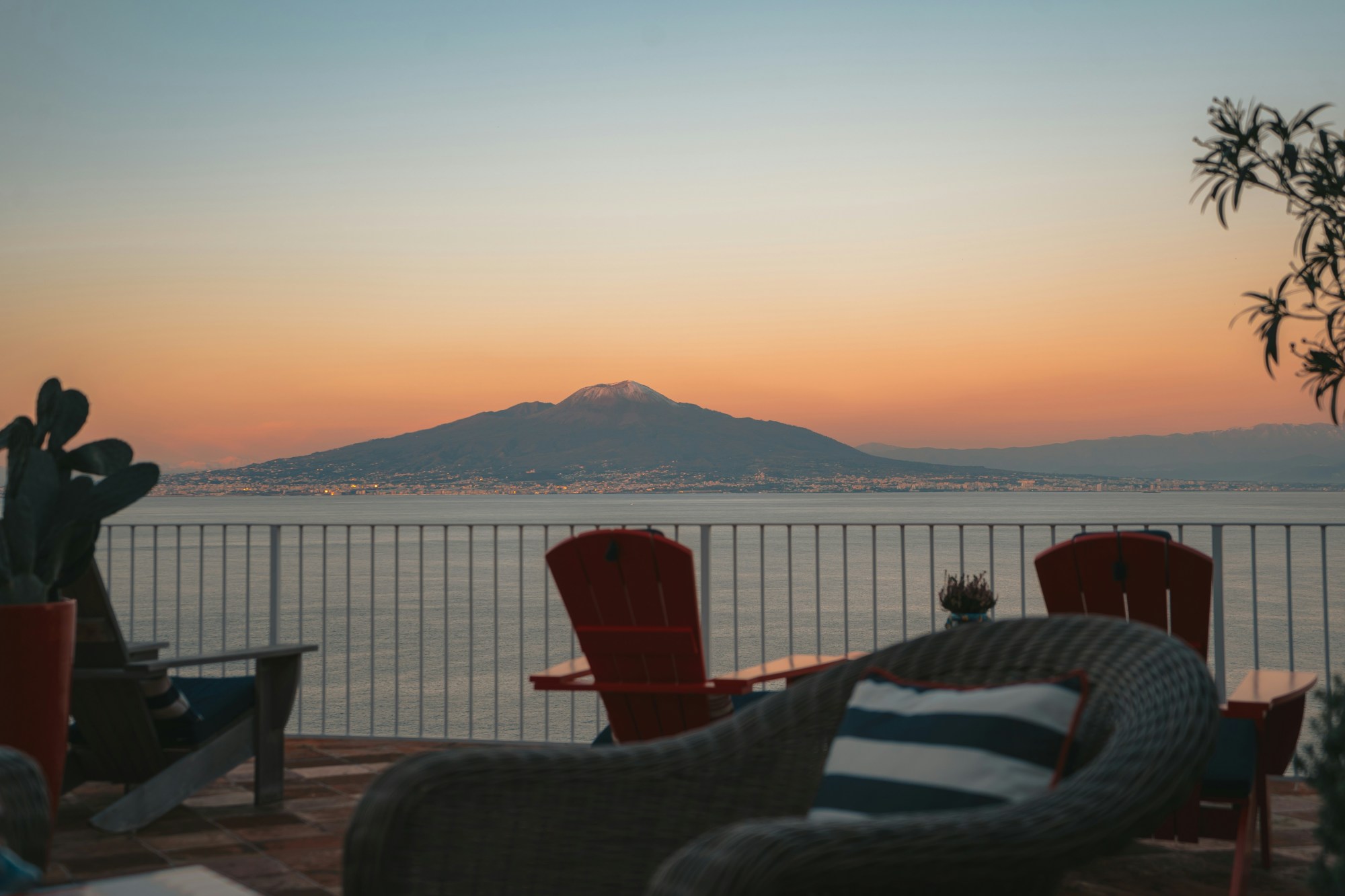 Patio with tables, chairs and view of sea during the sunset