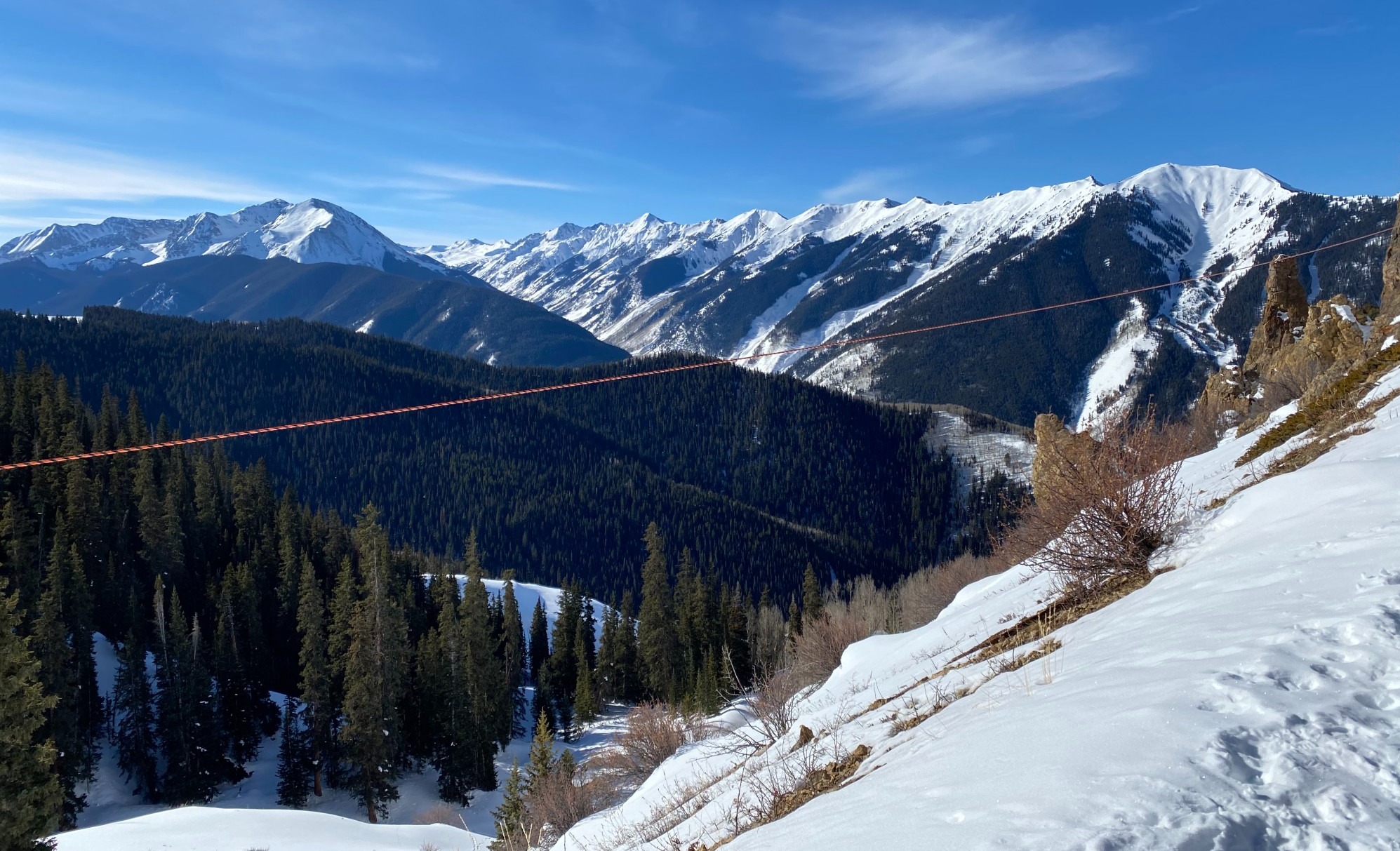 Snow covered mountains on a sunny, almost clear blue day.