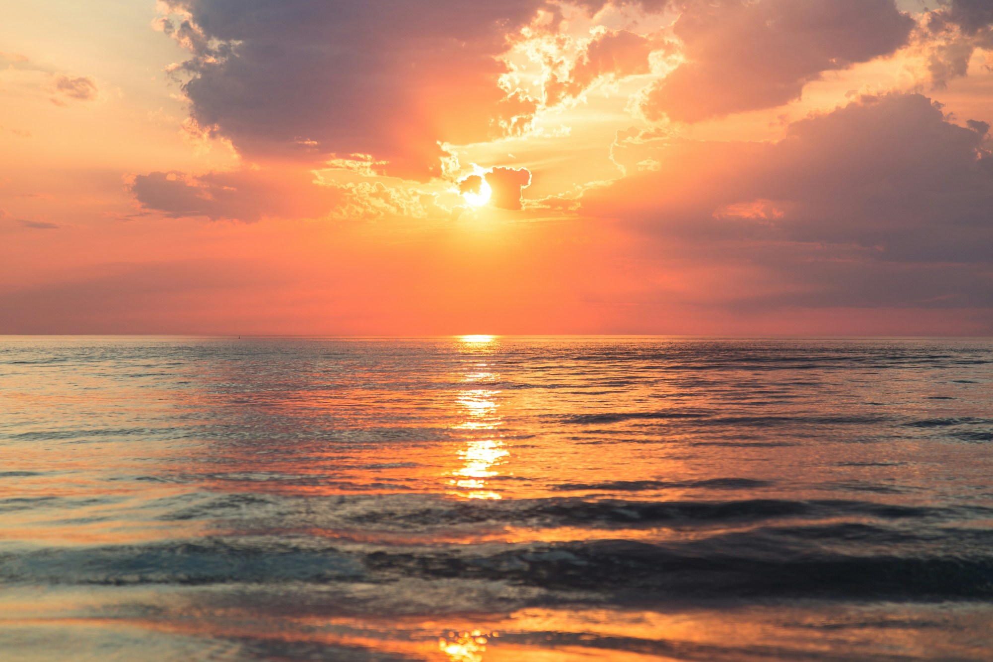 The sea under white clouds at golden hour