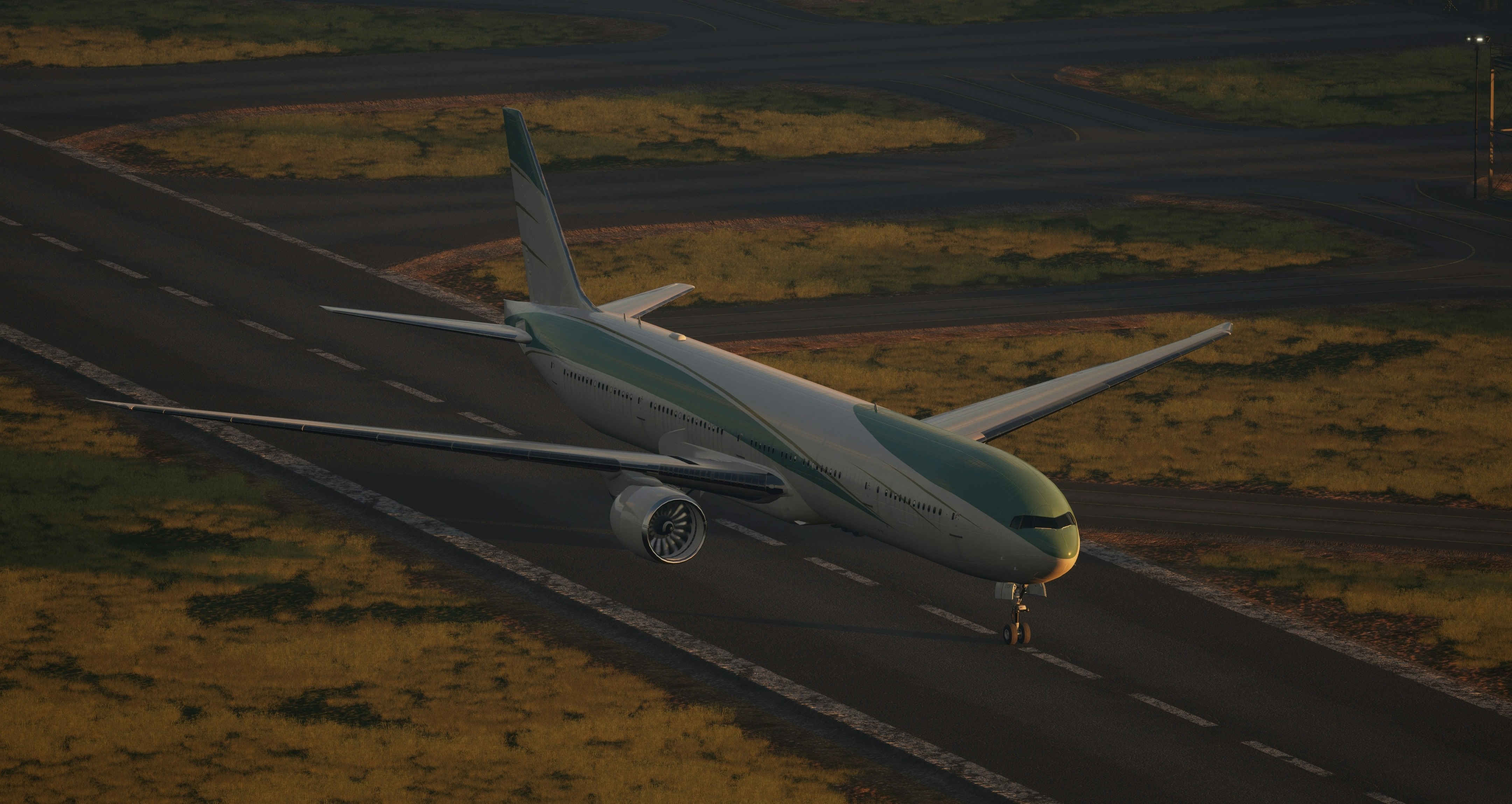 The image shows an airplane touching down on a runway during sunrise or sunset.