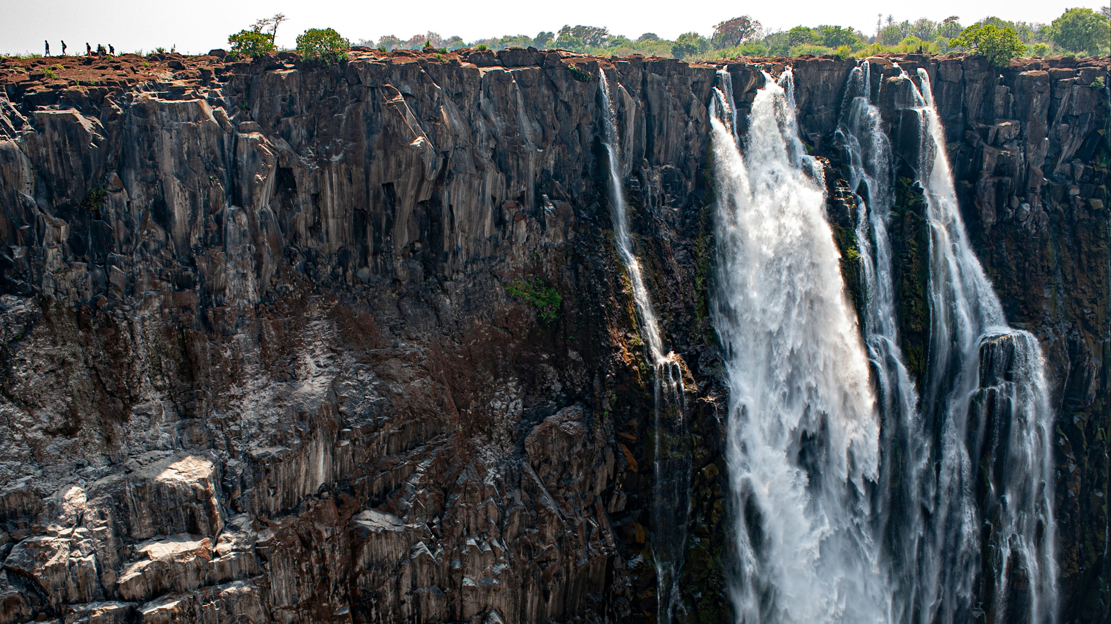 An enormous waterfall with several streams cascading over a steep face.