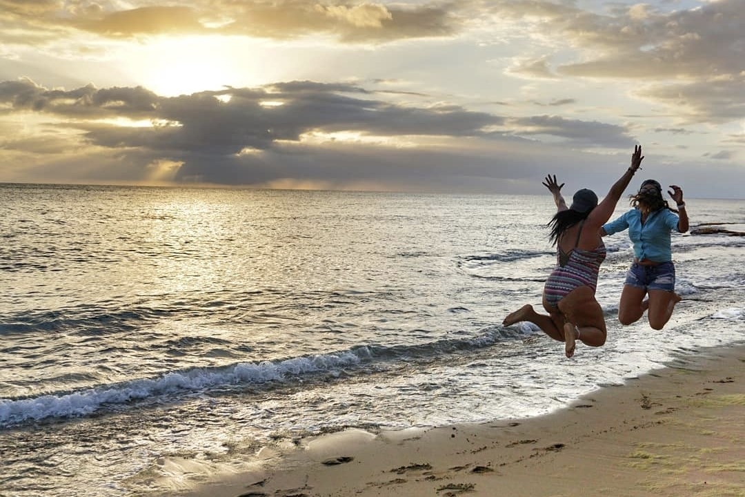 Girls jumping on the shore of a beach in Fajardo.