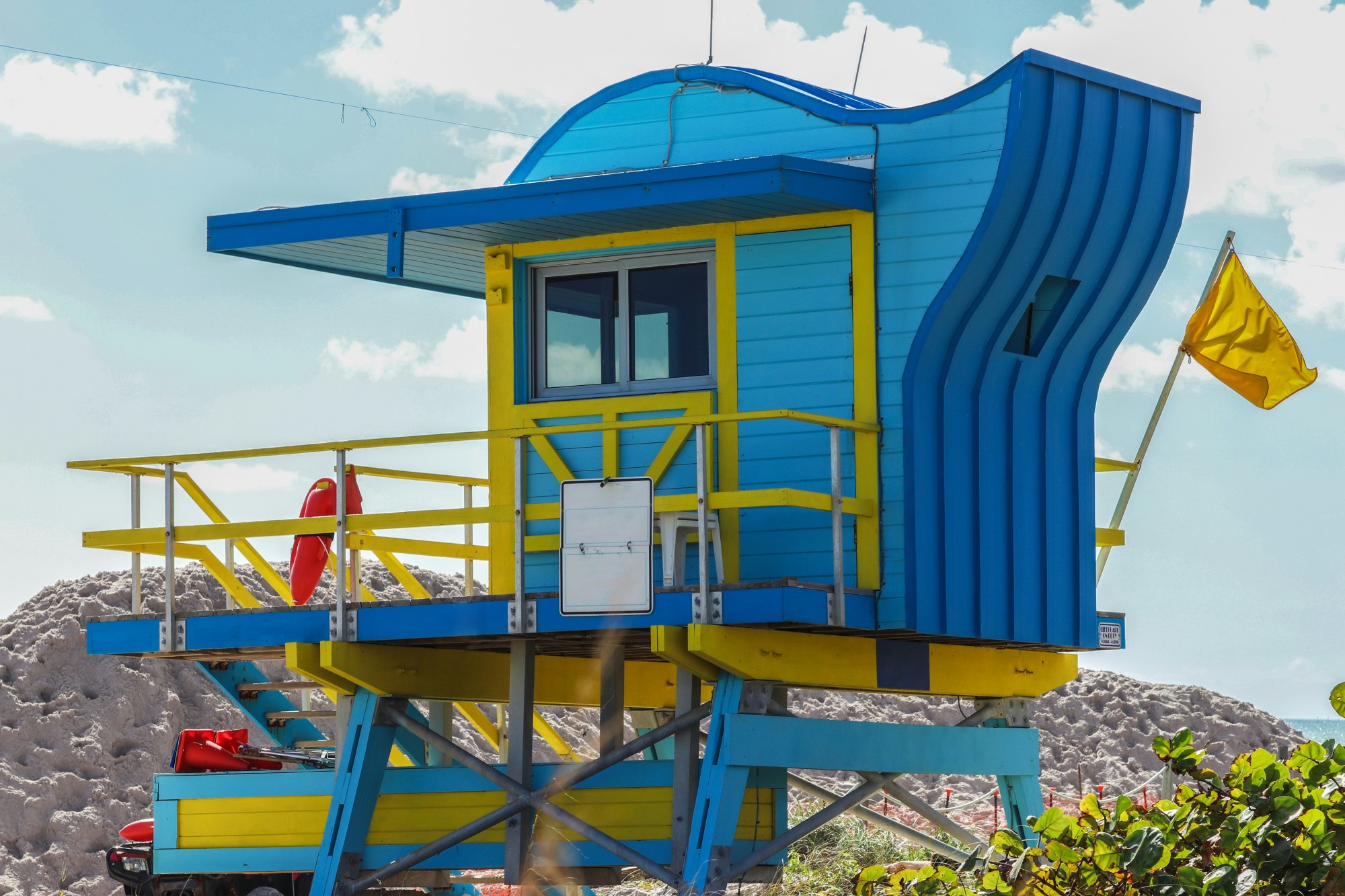 Blue and yellow hut on beach.