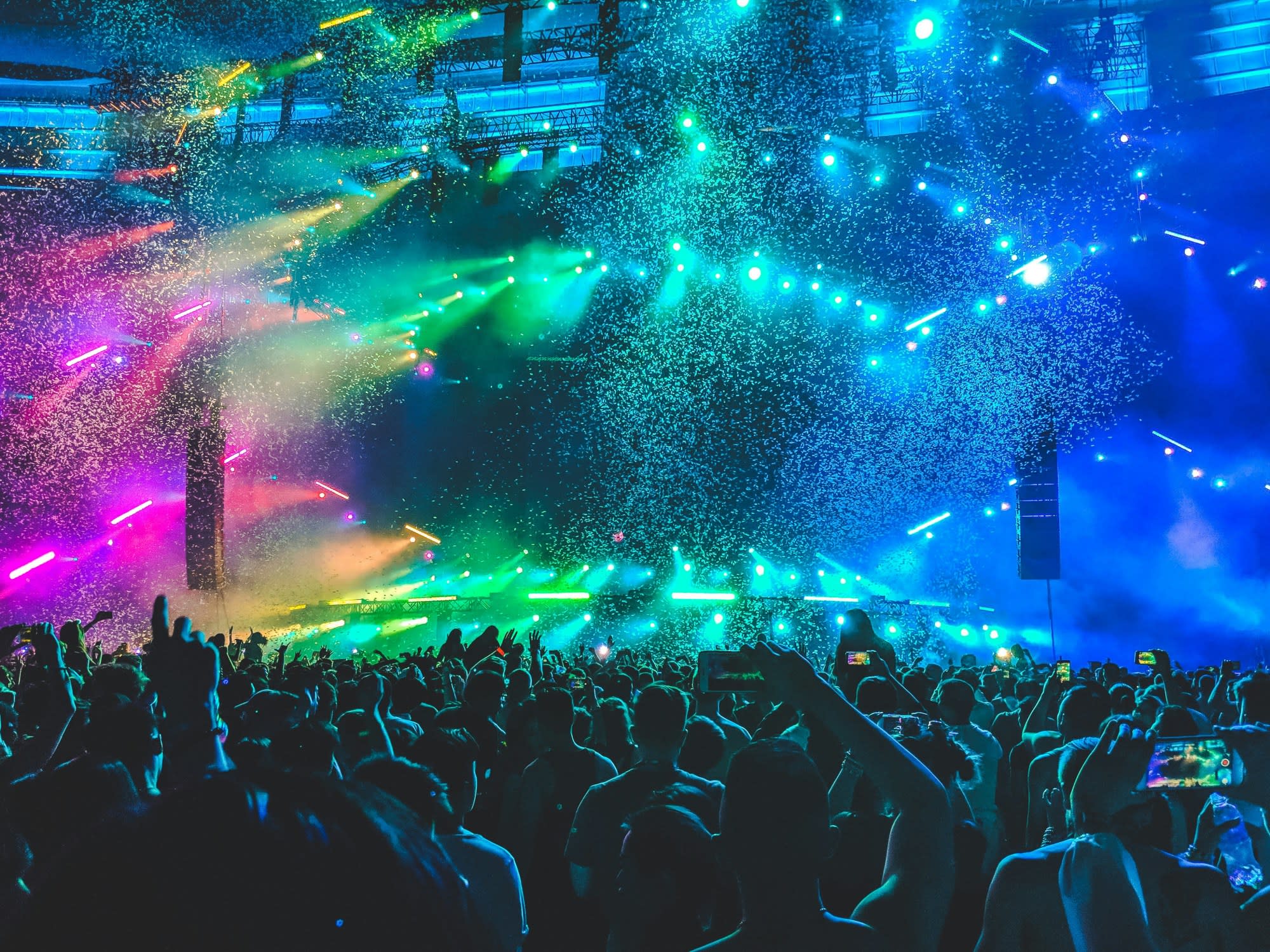 A crowd cheers as music blasts and colored paint splashes out into the crowd.