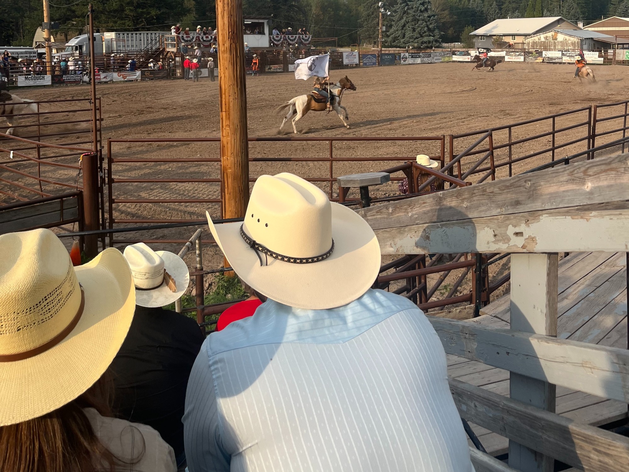 People in cowboy hats sitting in stands watching a rodeo