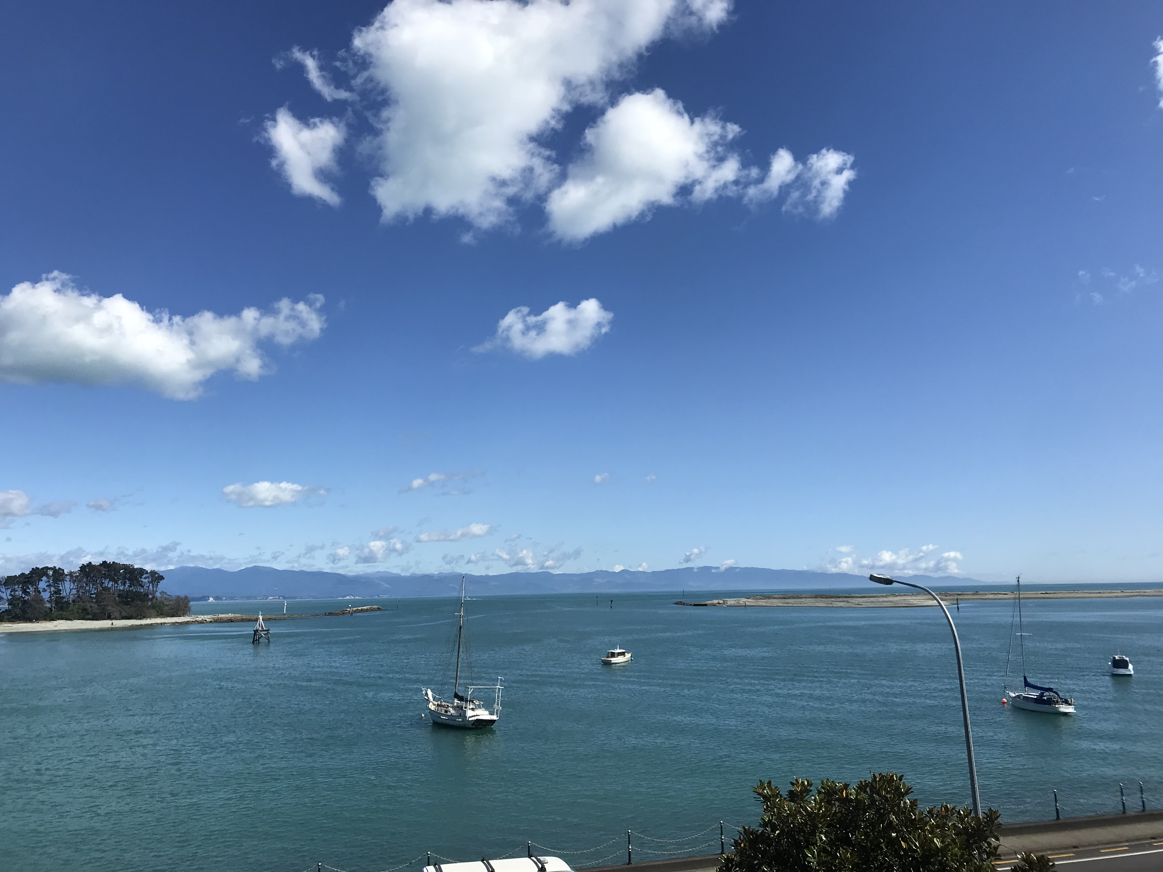A view of the serene ocean with boats sailing on a clear day.