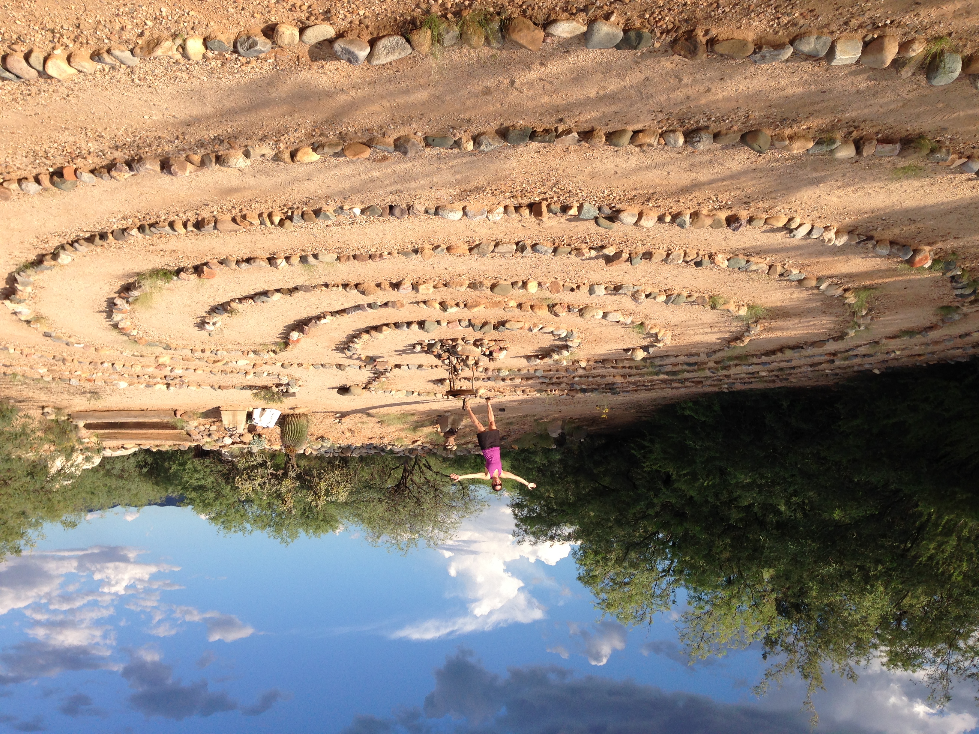 Travel advisor Holly posing in desert landscape with many circles of rocks