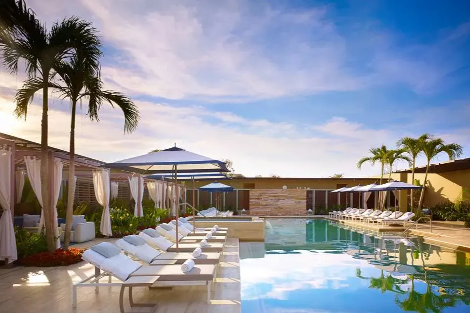 Cabanas, palms and loungers line either side of a gorgeous pool
