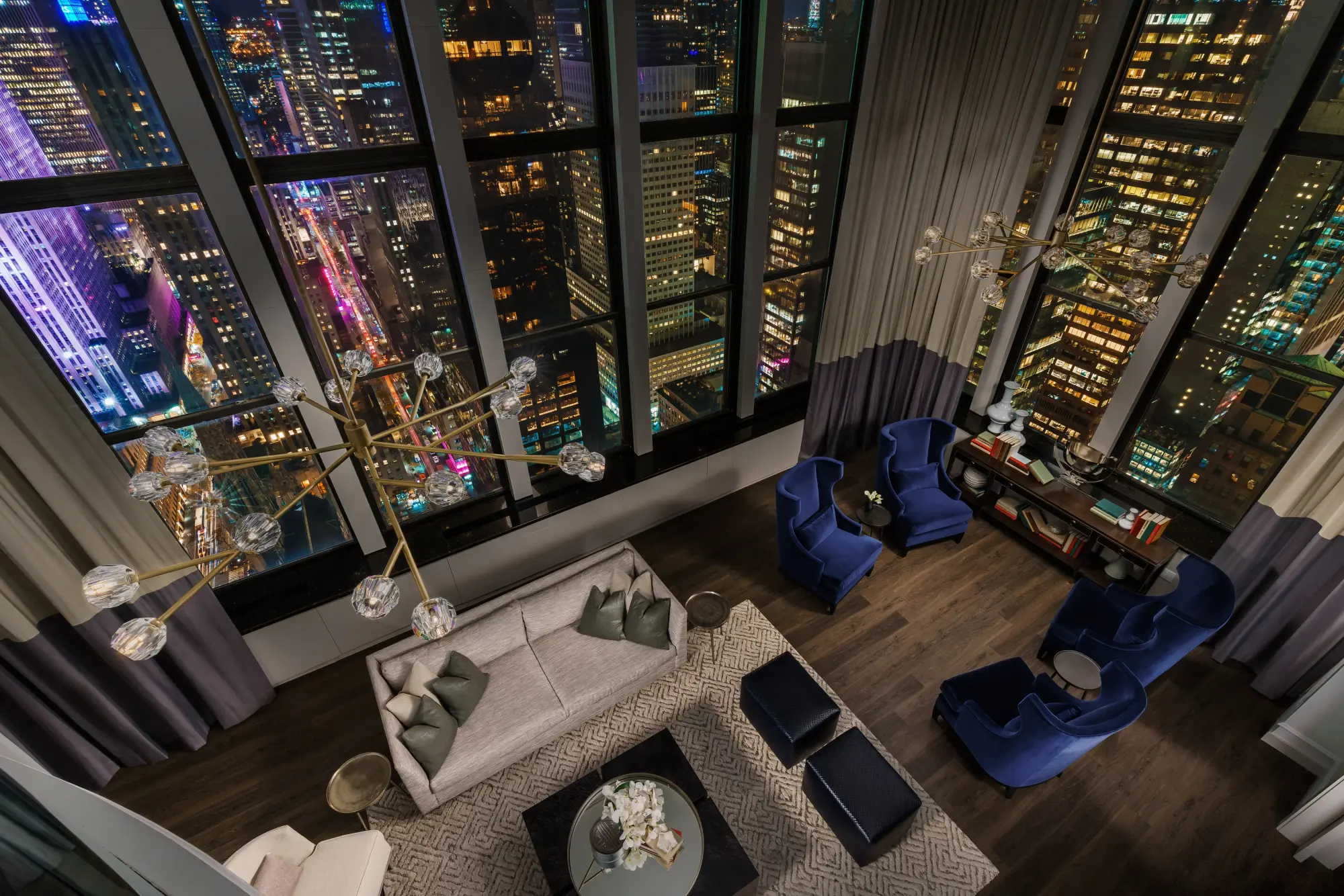 A mix of mid-century modern and contemporary decor fill a sophisticated lounge with floor-to-ceiling windows providing excellent city views