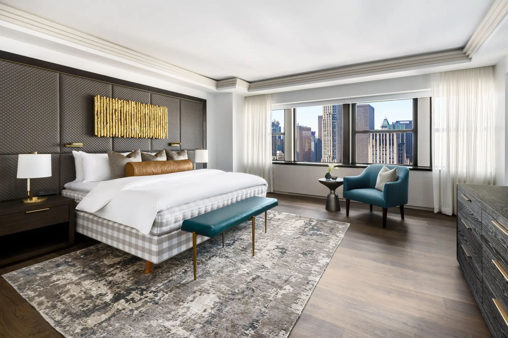 Massive suite with a stylish rug, contemporary furniture, plush bedding and a skyline view