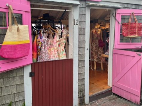 A shop with pink doors on a sunny day.