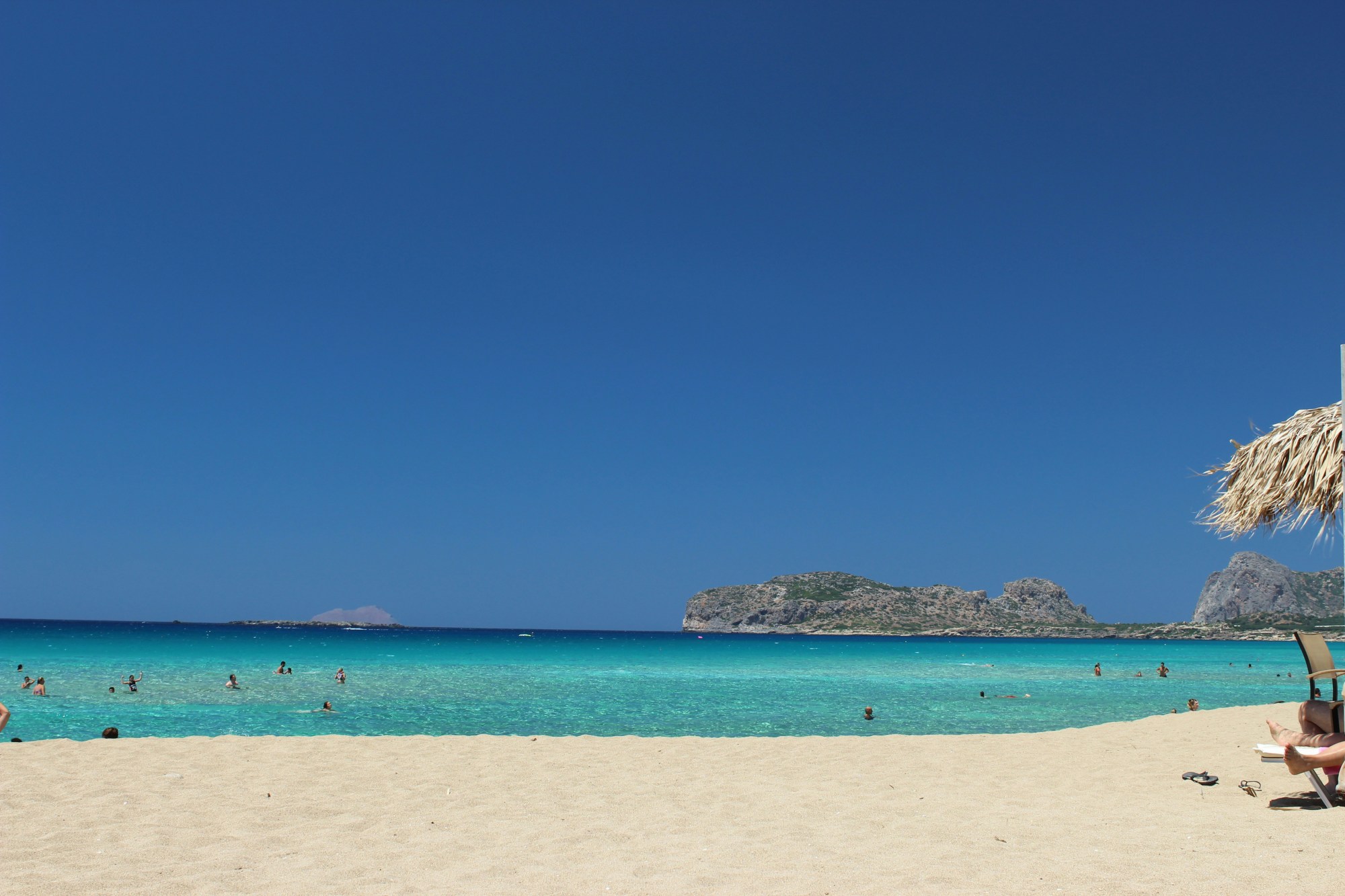 People swimming on beach on a sunny day.
