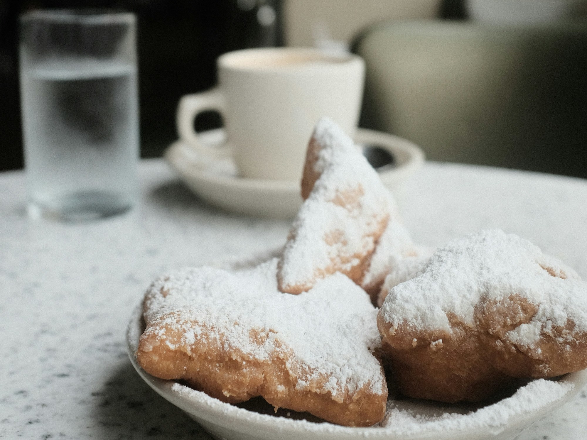 Three pastries covered in powdered sugar on a plate
