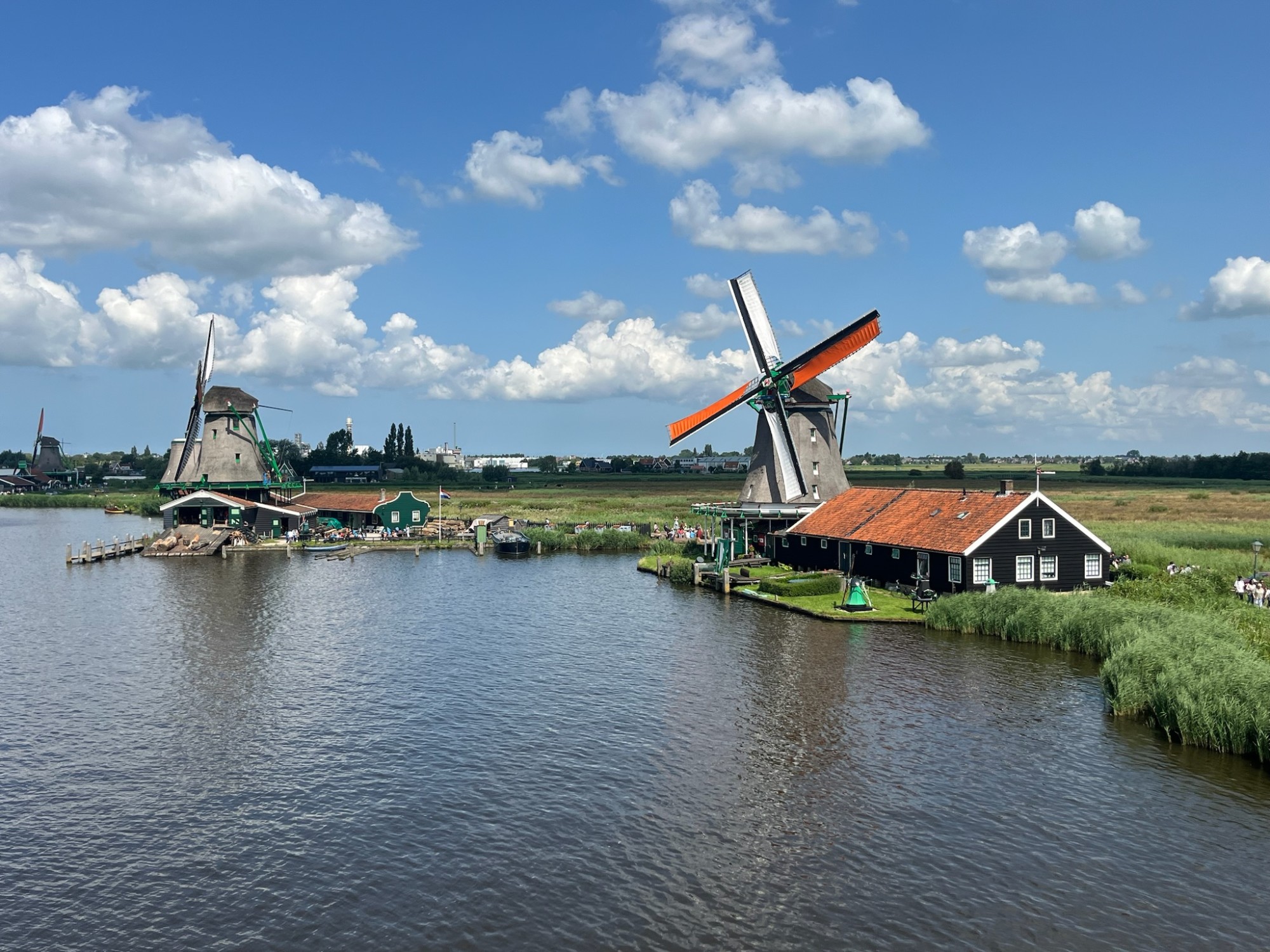 Windmills by a body of water during the daytime.