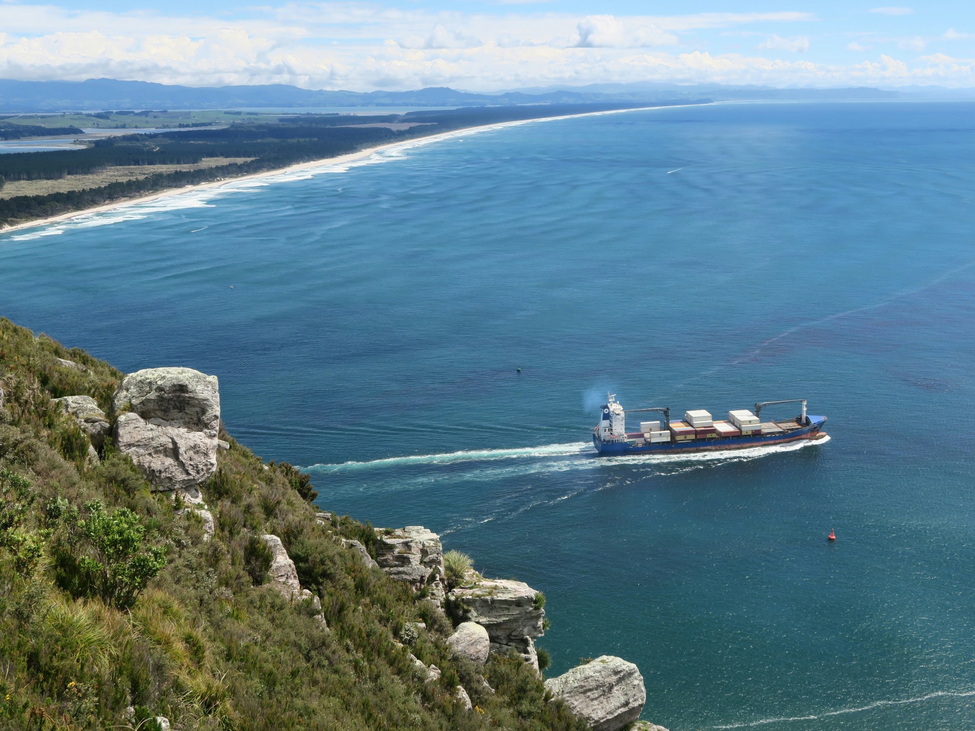A view of rocky cliffs and the ocean during the day.