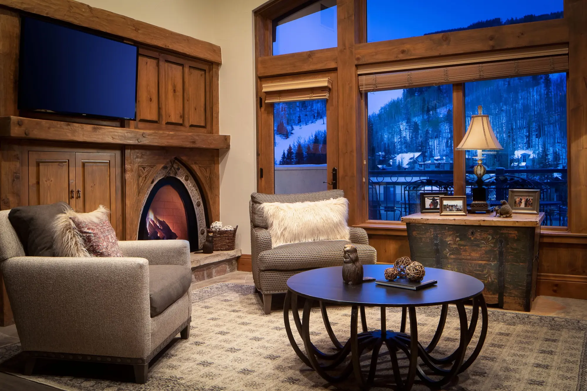 An elegant rustic theme permeates a living space at The Hythe, a Luxury Collection Resort, Vail with a view of snowy slopes and mountain pines